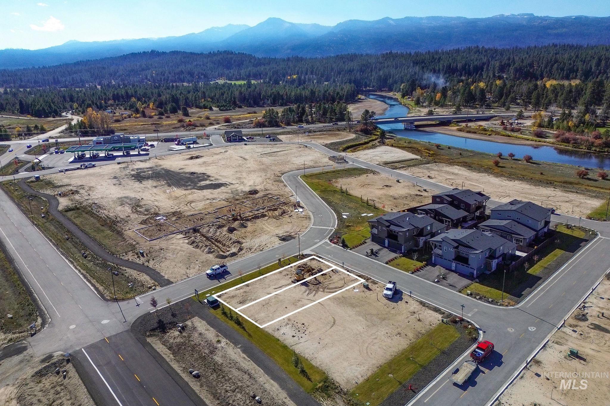 Drone / aerial view of a heavily wooded area and a water and mountain view