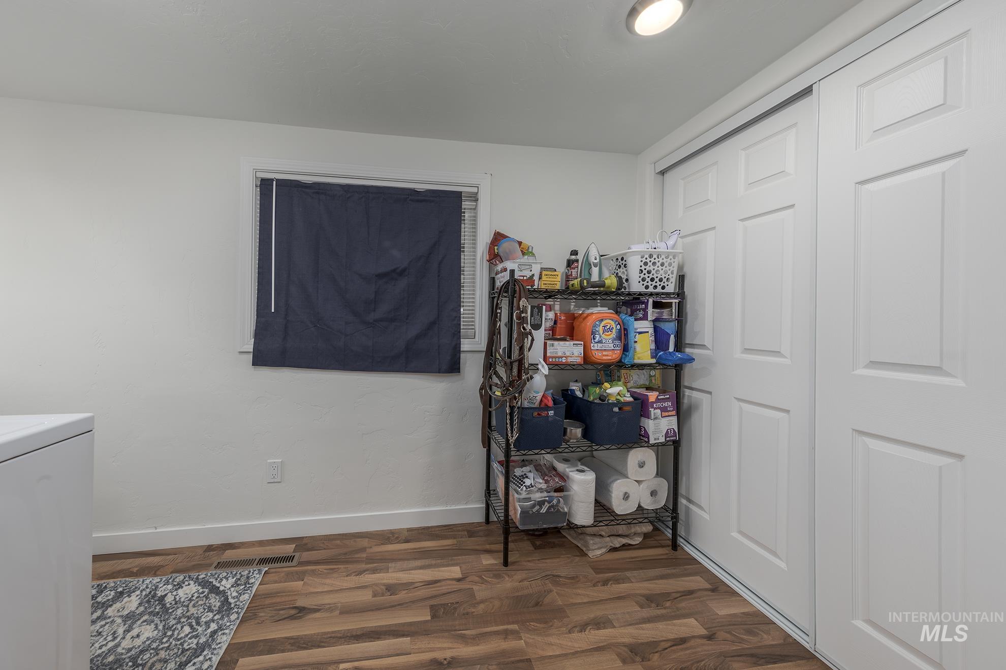 Laundry area with washer / dryer and dark wood-style flooring