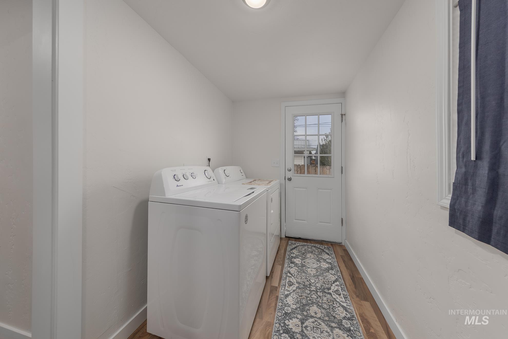 Laundry area featuring washer and clothes dryer and light wood-style flooring