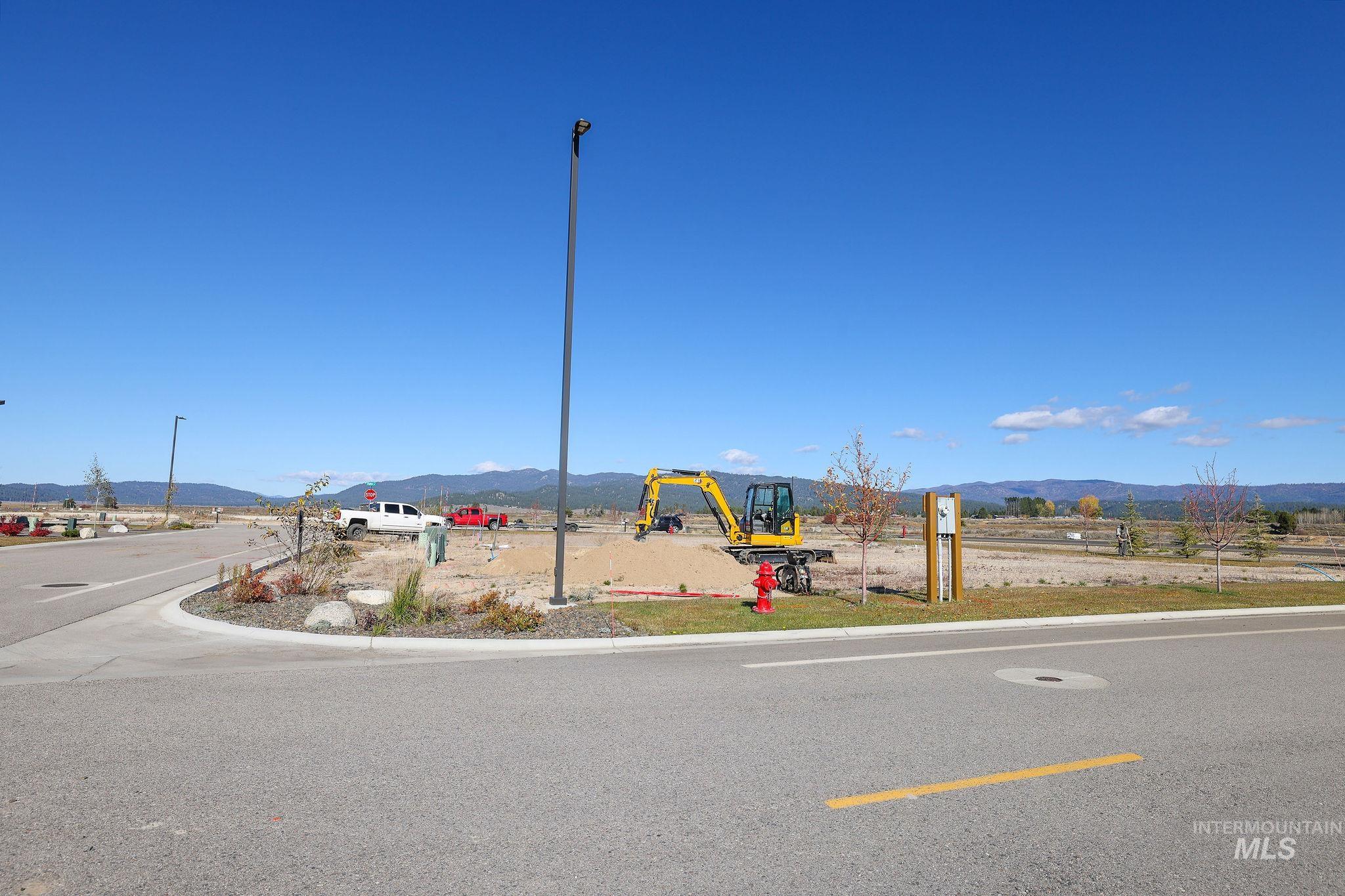 View of asphalt street featuring a mountain view, curbs, and street lighting