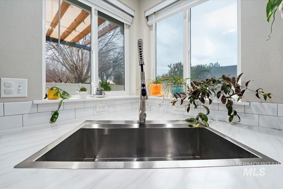 Kitchen view of a textured wall and light stone countertops