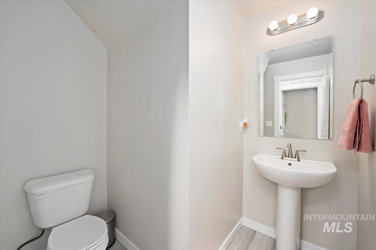 Half bath featuring baseboards and toilet