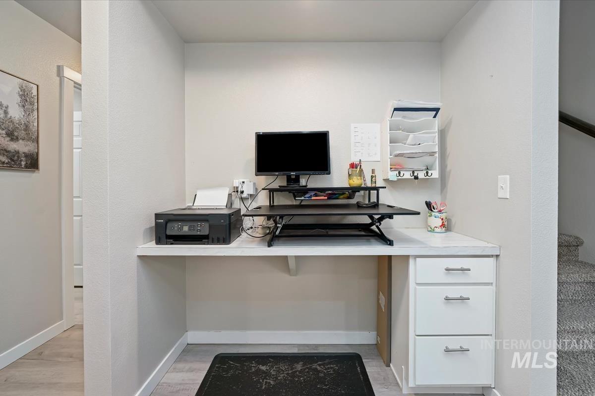 Office area featuring built in study area and light wood finished floors
