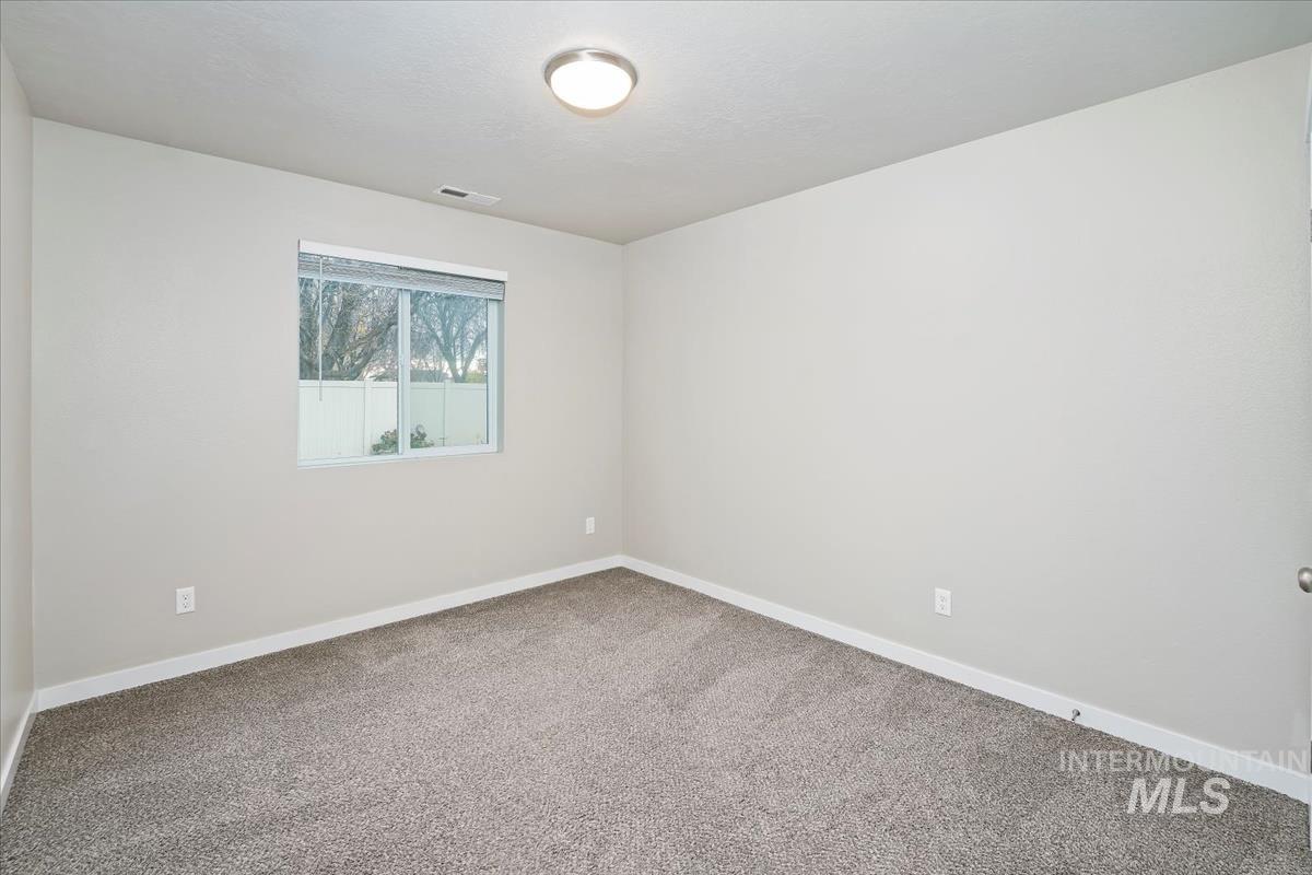 Empty room with carpet floors and baseboards