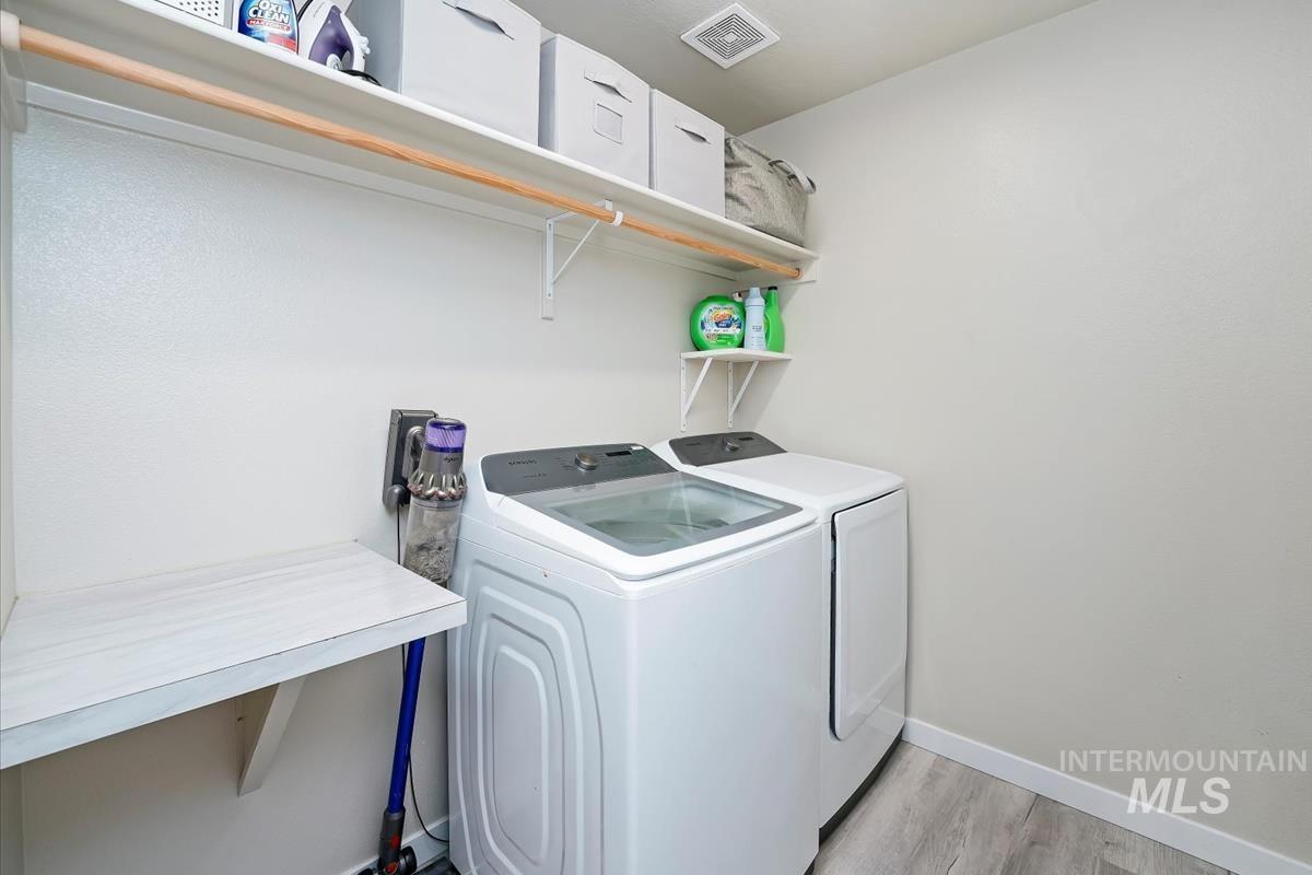Laundry room featuring light wood finished floors and independent washer and dryer