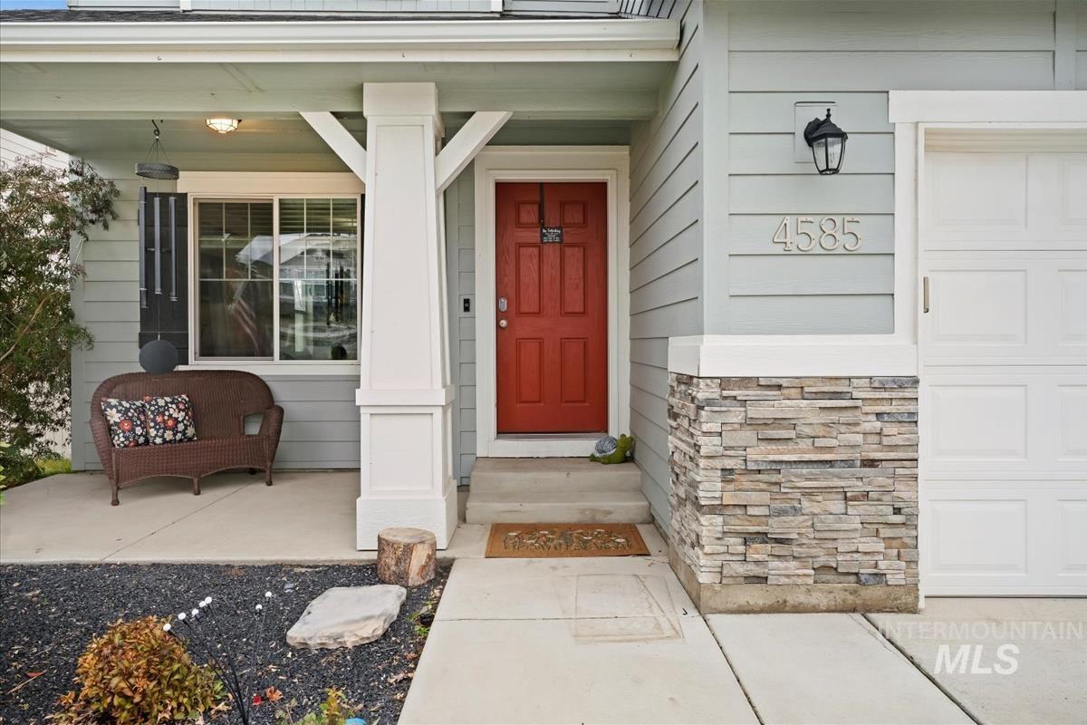 Entrance to property with stone siding and a porch