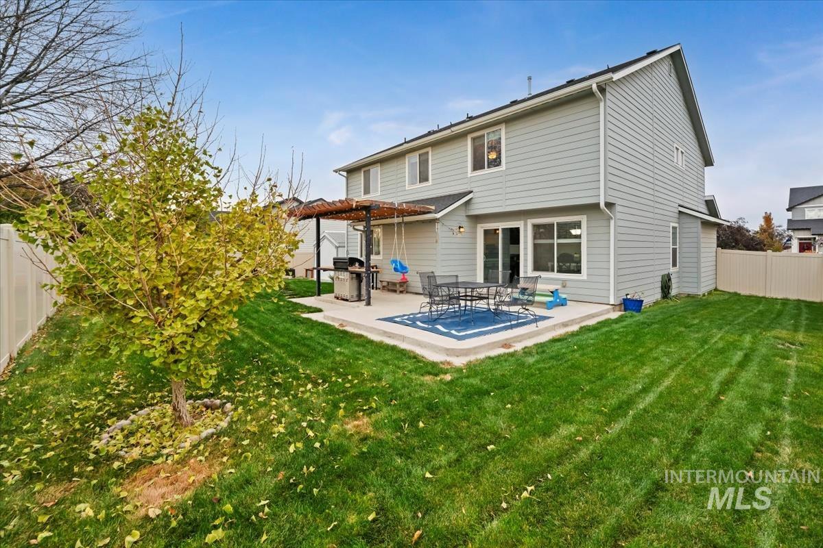 Back of house with a fenced backyard, a patio area, and a pergola