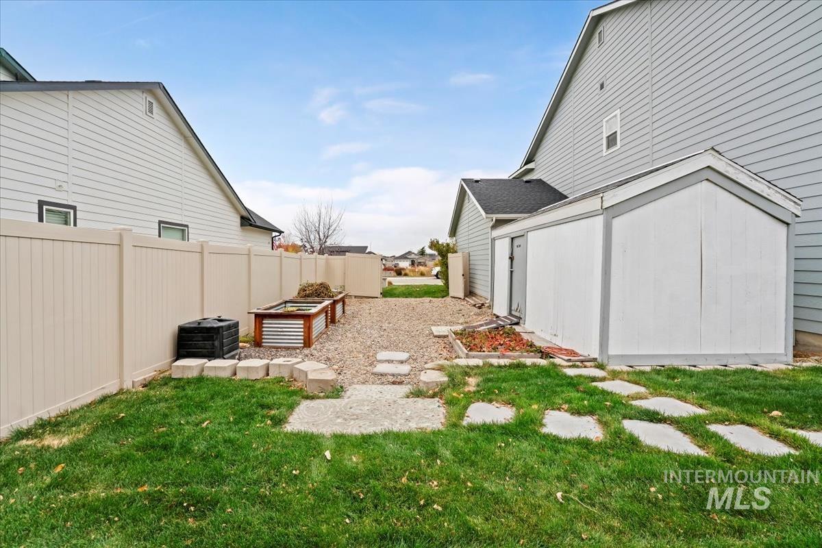 View of yard featuring a garden and a storage shed