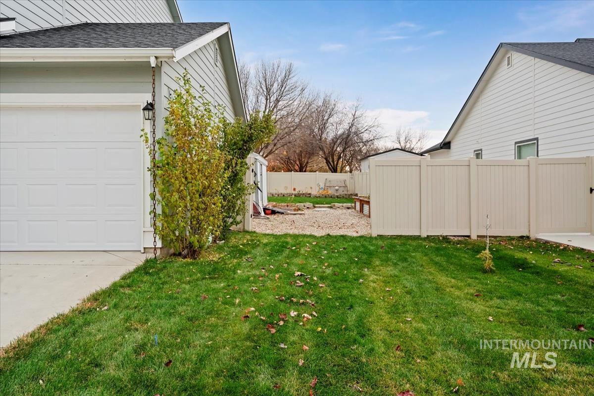 View of side of property featuring a shingled roof and a garage