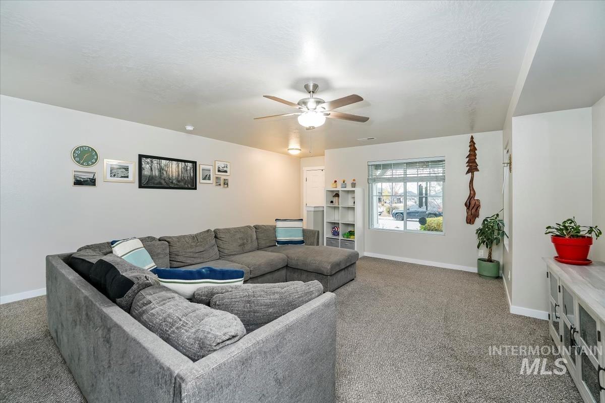 Living area with carpet flooring and ceiling fan