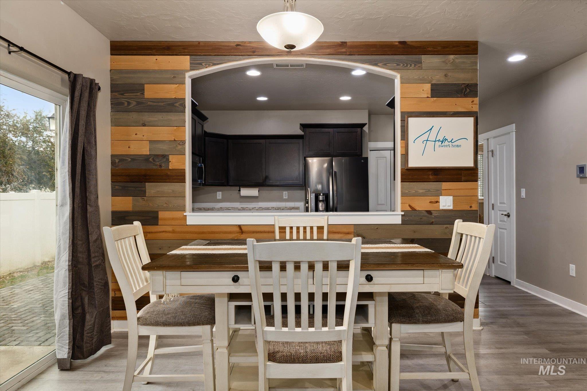 Dining room featuring wood walls, light wood-type flooring, and recessed lighting