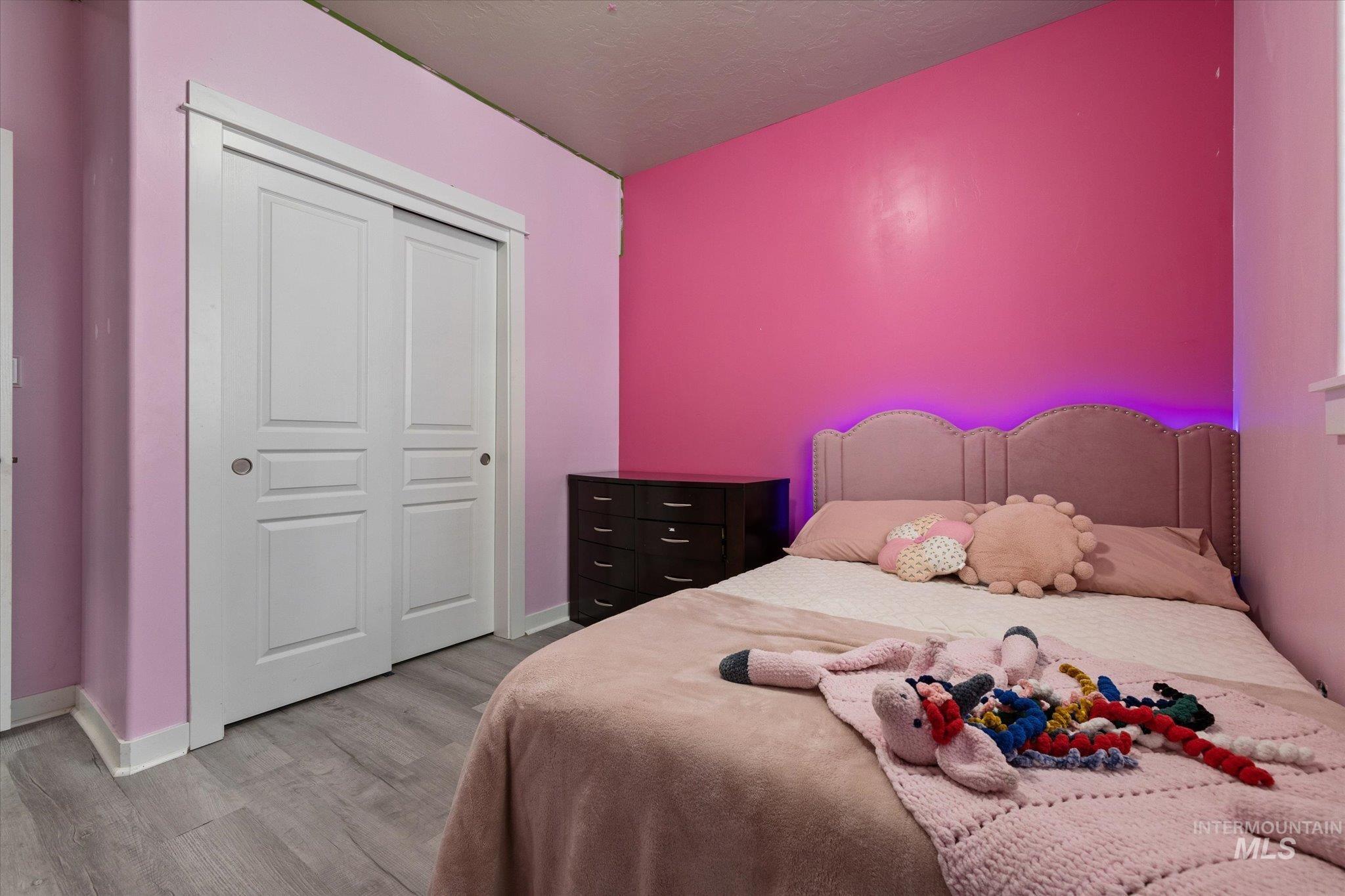 Bedroom with light wood-type flooring and a closet