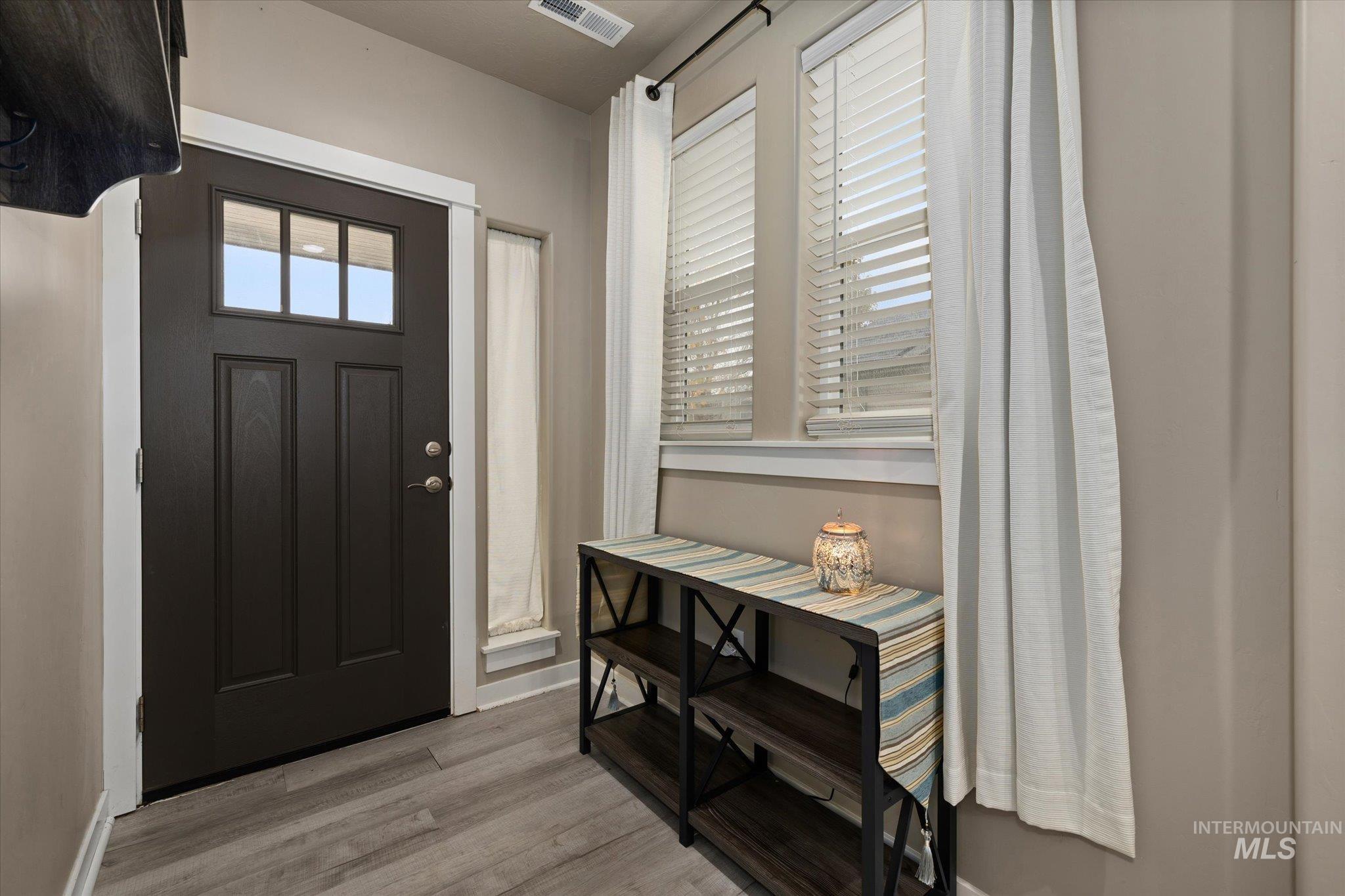 Foyer entrance featuring light wood-type flooring and baseboards