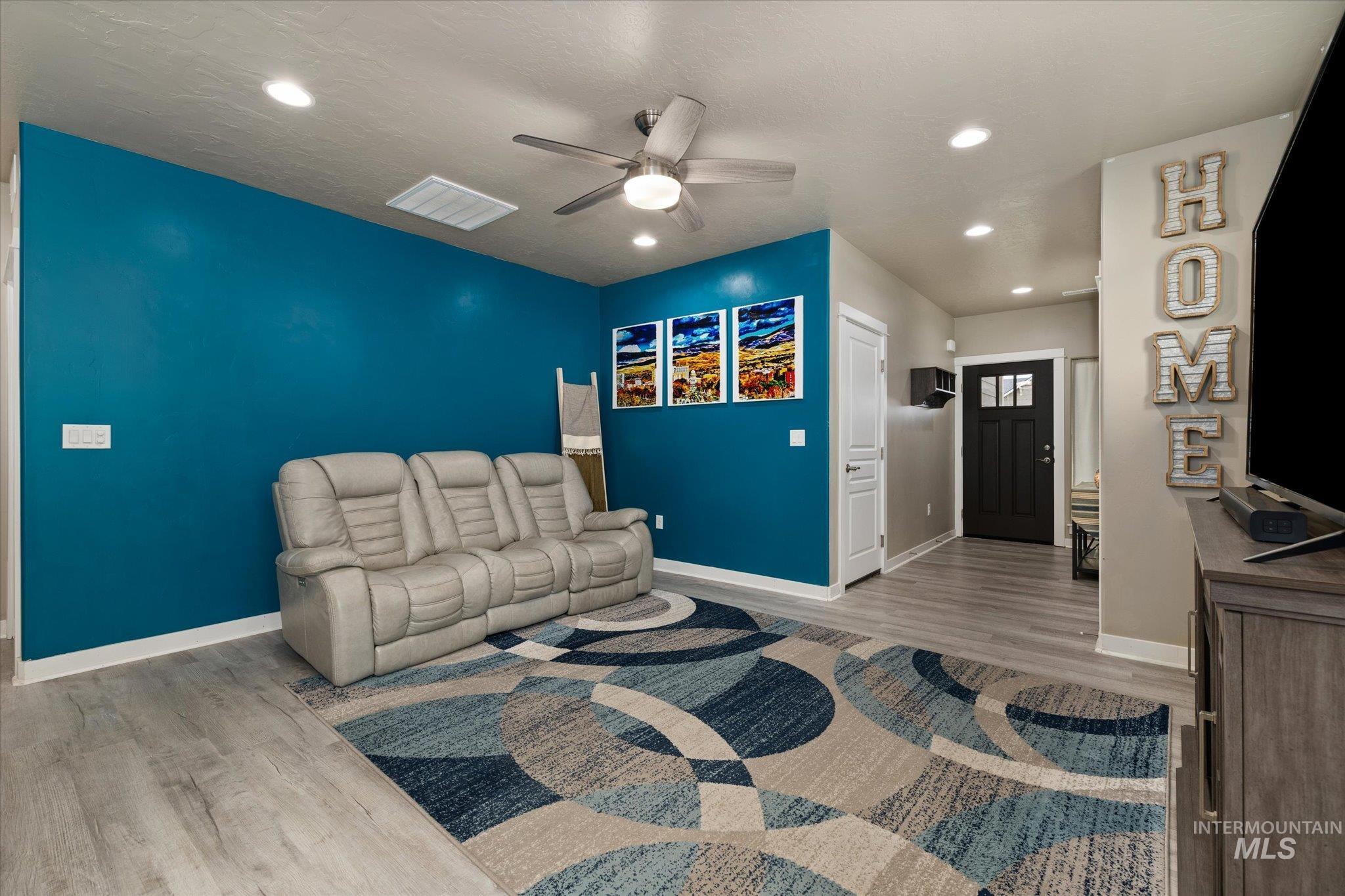 Living room with recessed lighting, light wood-style floors, and a ceiling fan