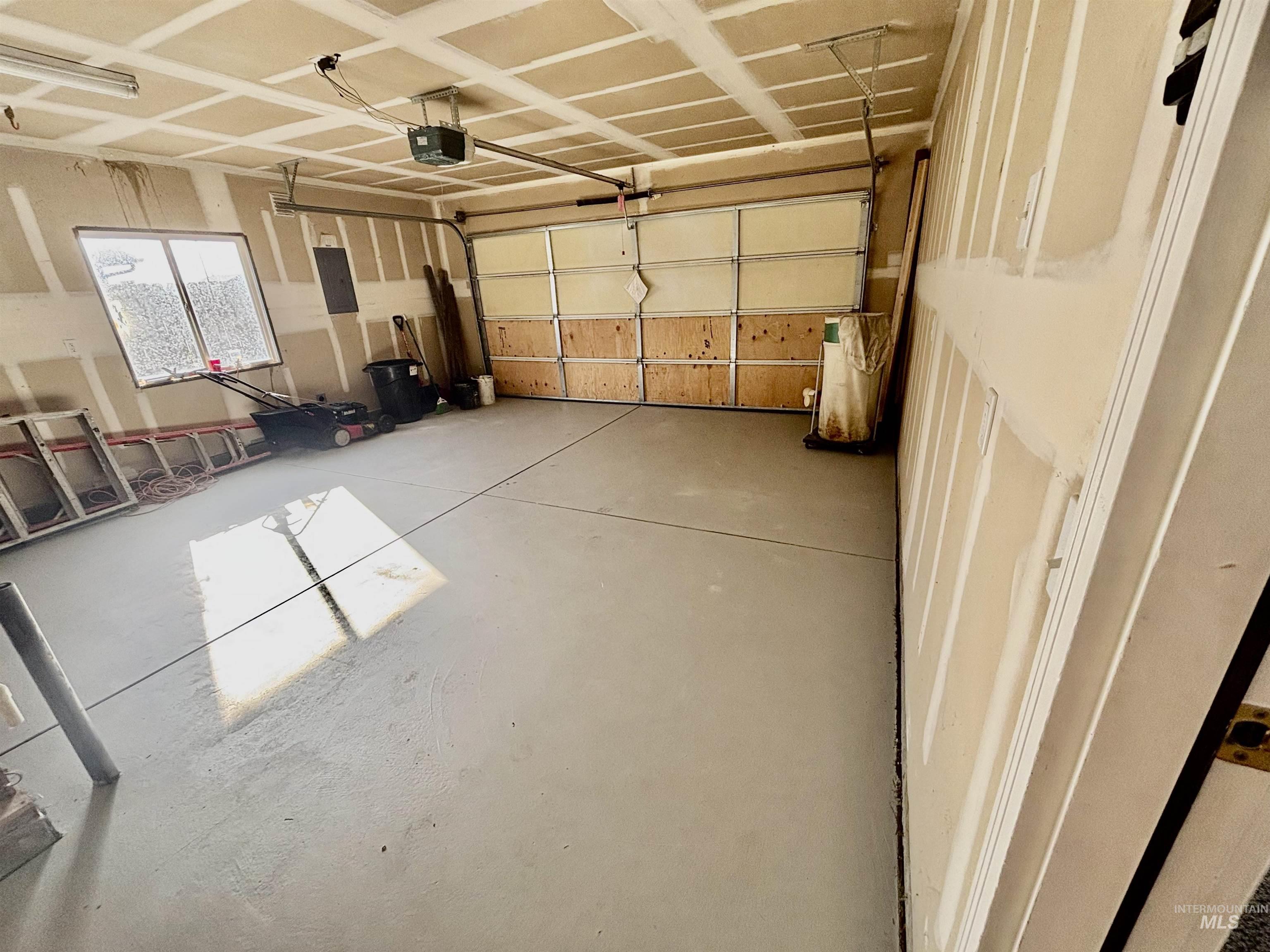 Garage featuring a garage door opener and electric panel