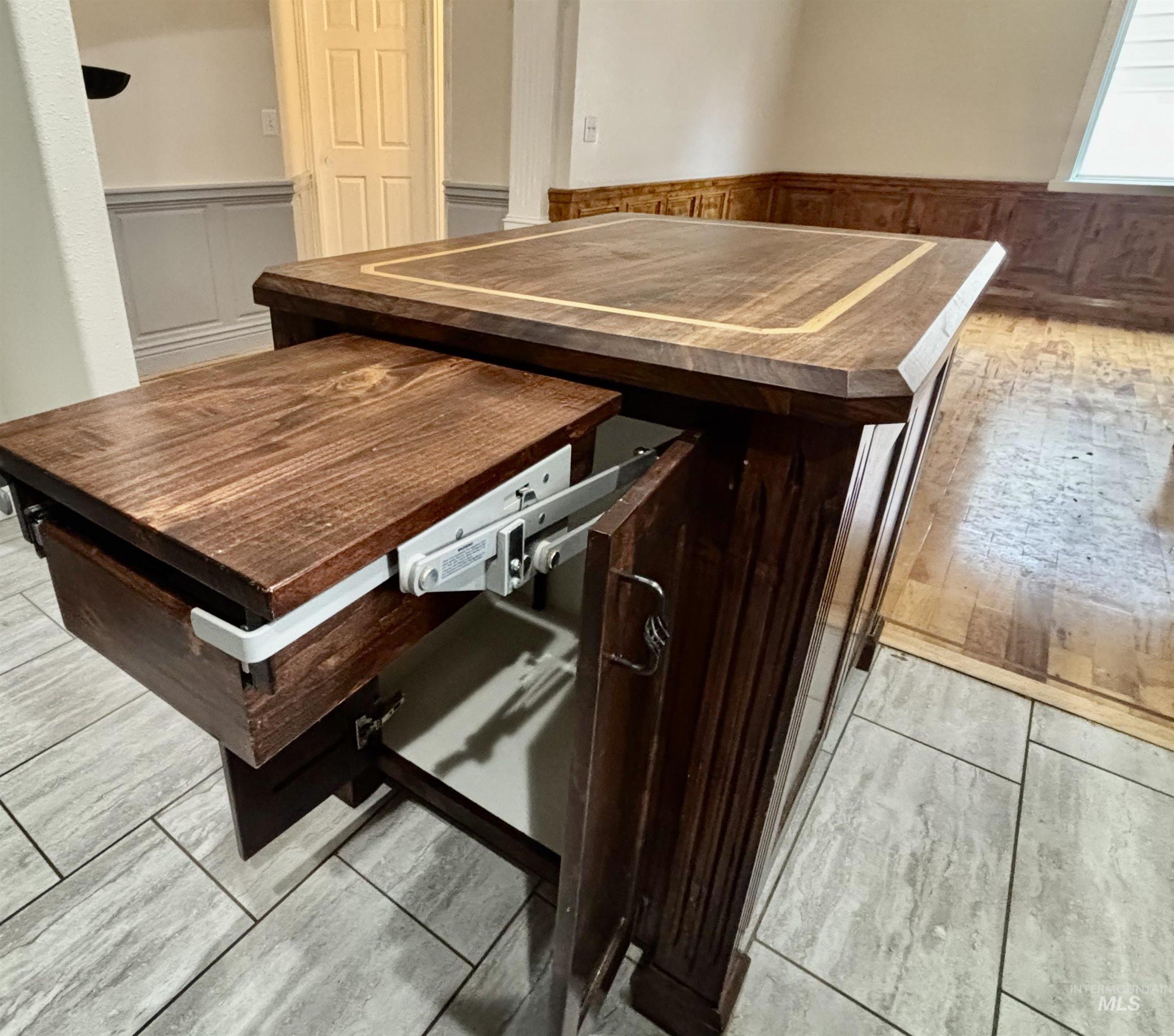 Kitchen view of wainscoting, dark brown cabinets, wood walls, butcher block countertops, and light wood-style flooring