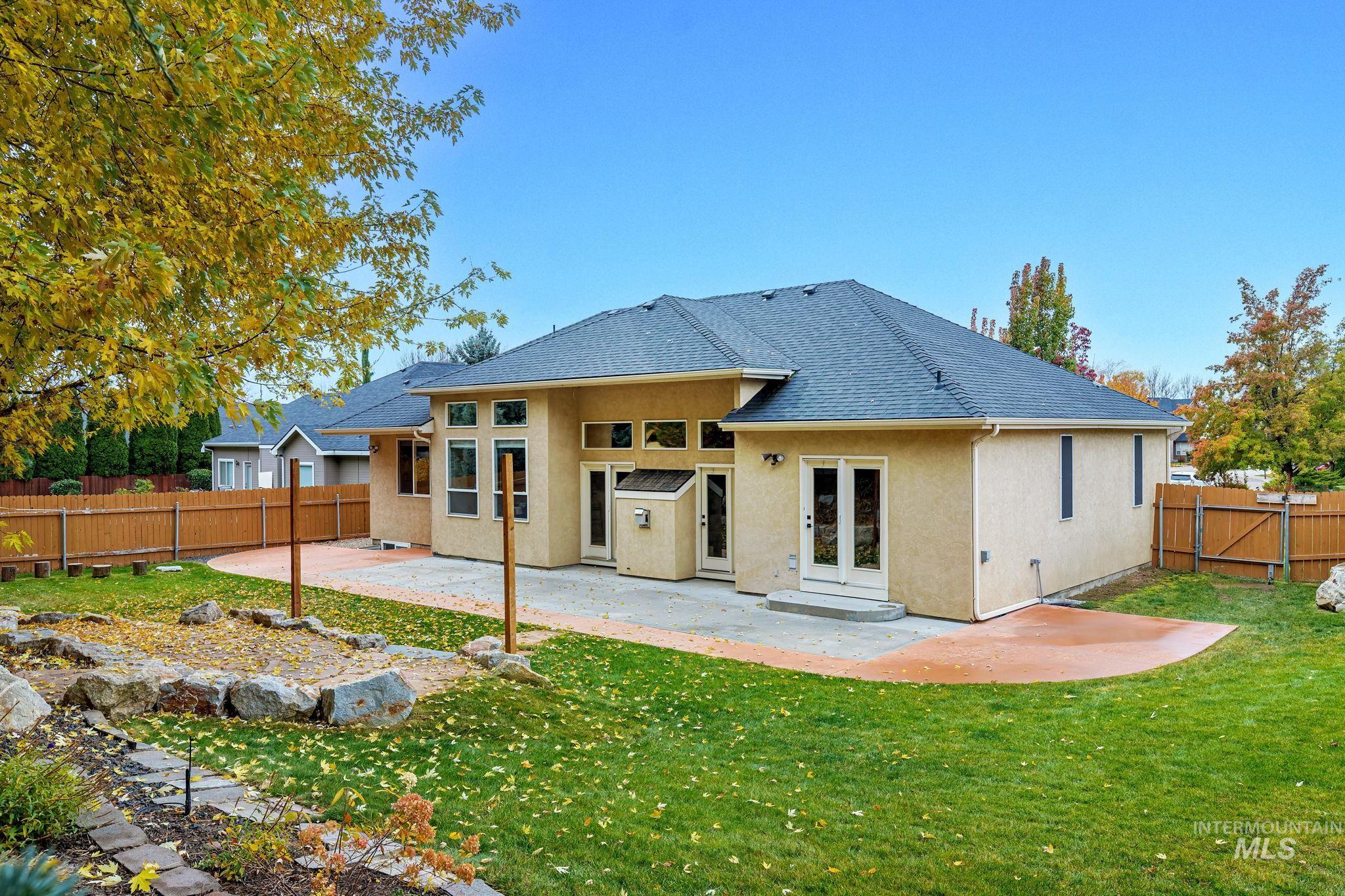Rear view of property with a patio, stucco siding, a fenced backyard, and french doors