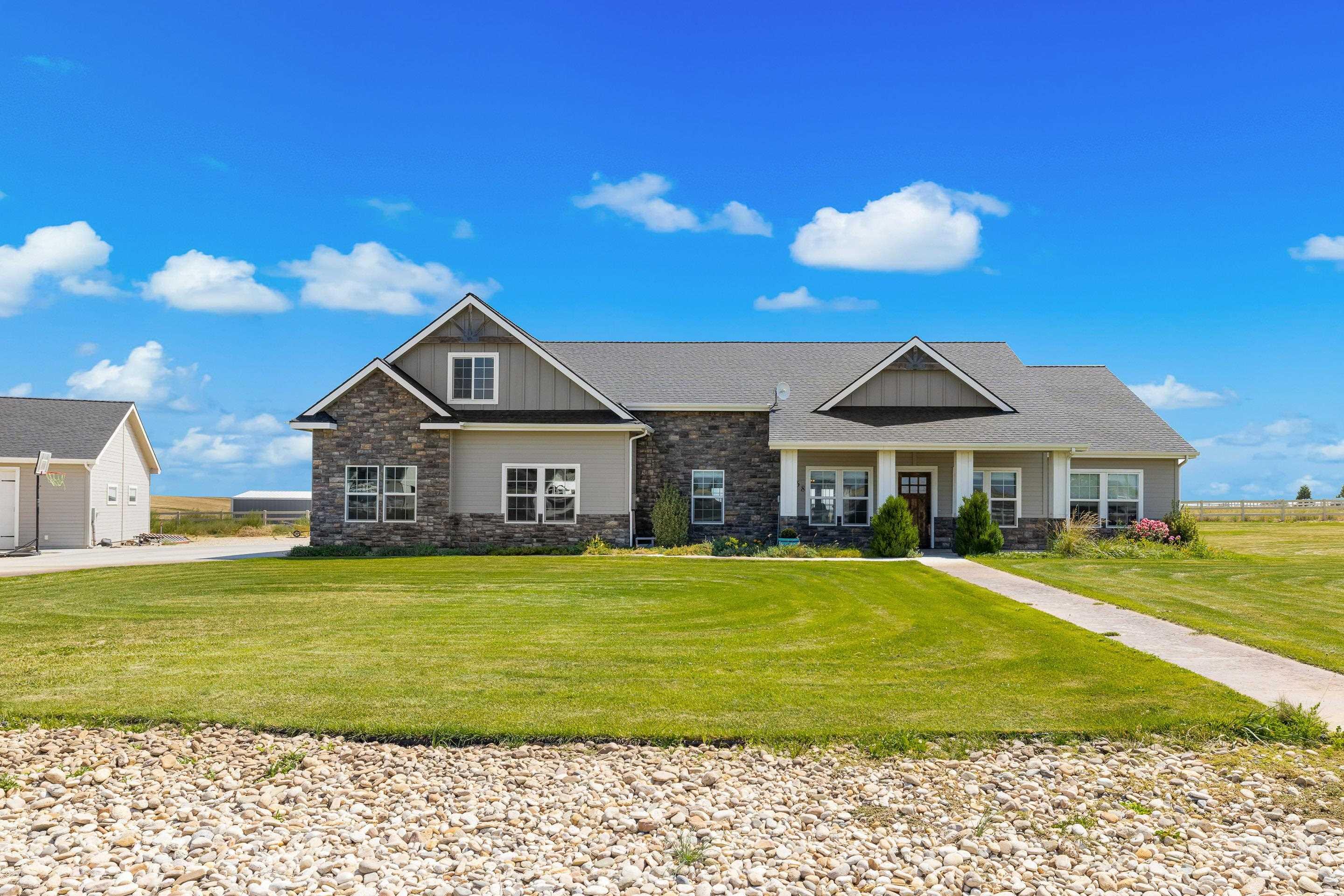 Craftsman house with stone siding, board and batten siding, a front lawn, and a porch