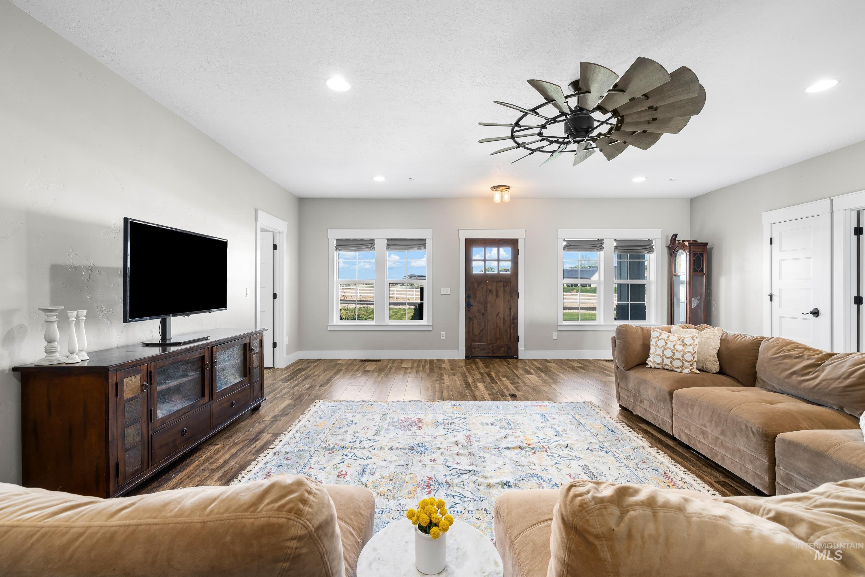 Living room with wood finished floors, ceiling fan, and recessed lighting