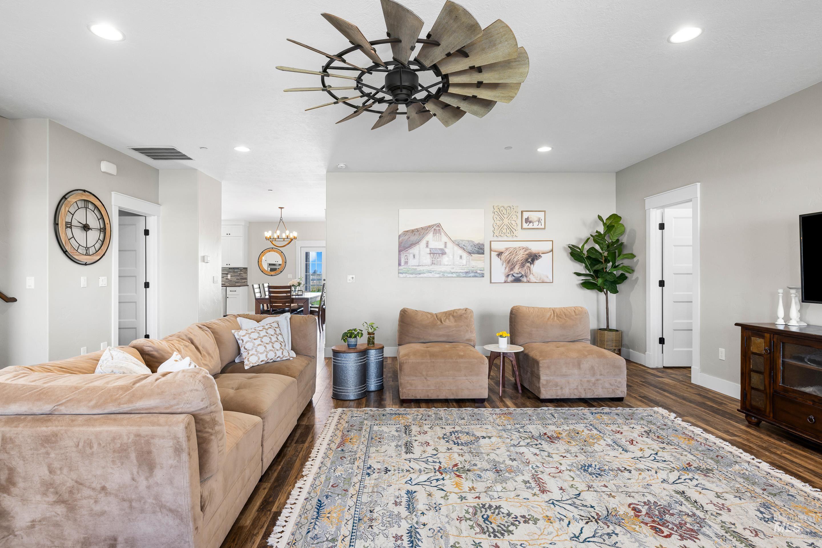 Living room featuring recessed lighting, dark wood-style flooring, a chandelier, and a ceiling fan