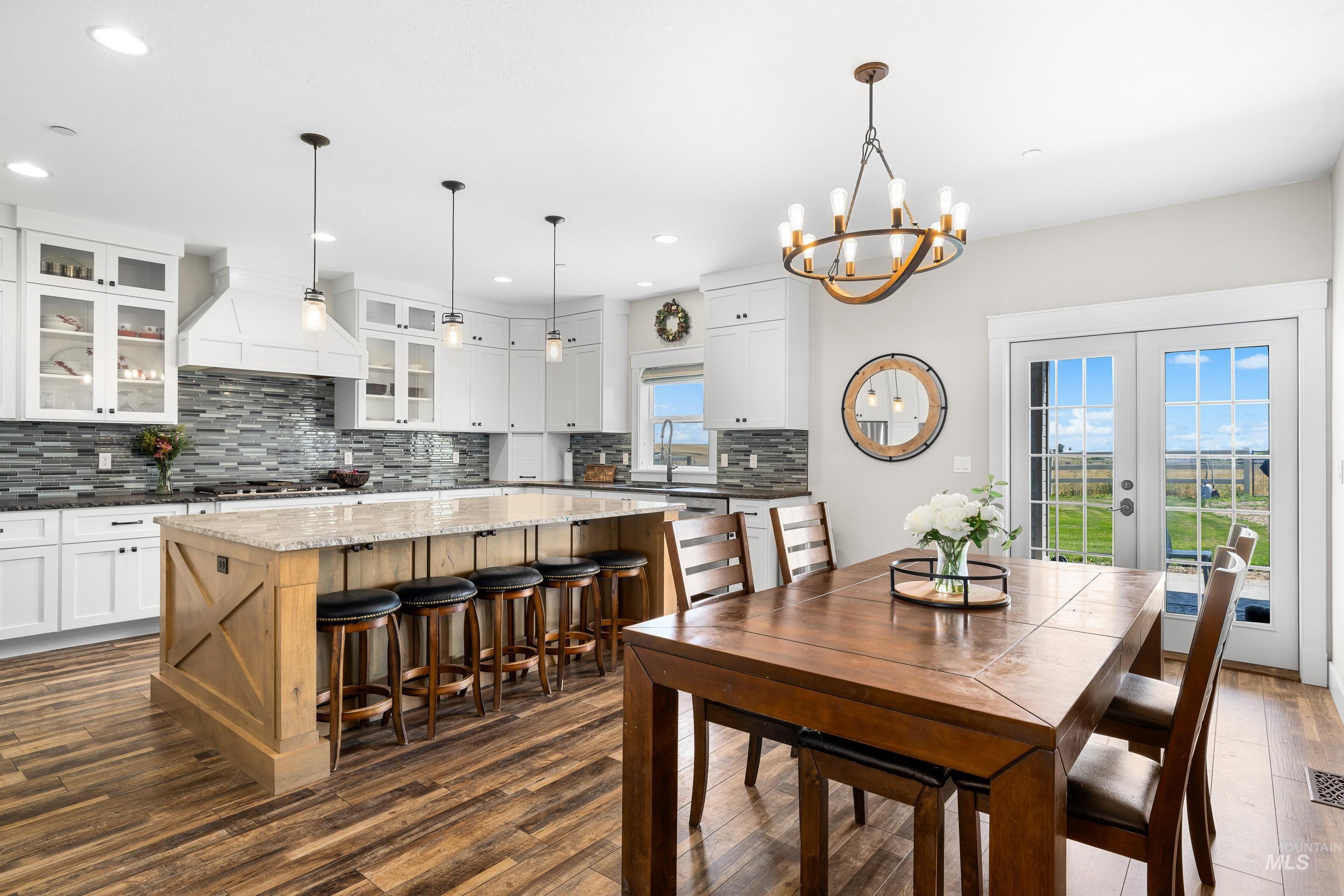 Dining room with french doors, dark wood finished floors, a chandelier, and recessed lighting