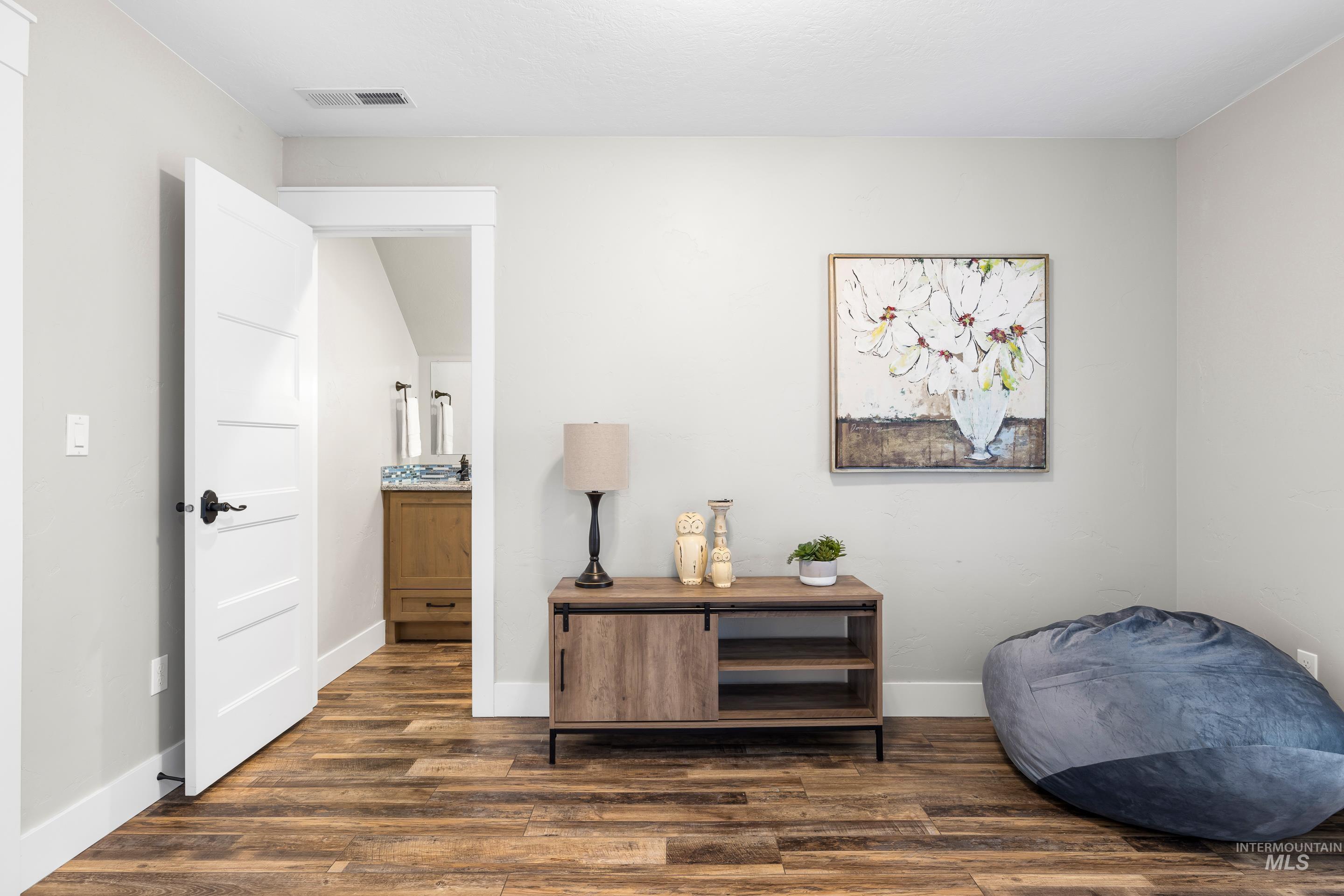 Living area with dark wood-style flooring and baseboards