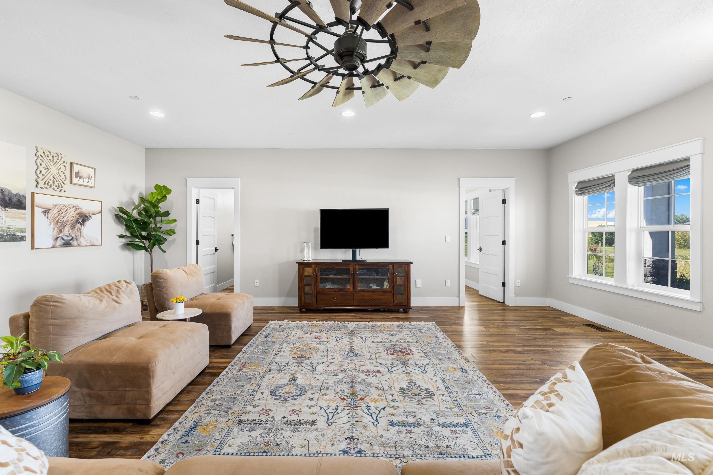 Living room with recessed lighting, dark wood-type flooring, and a ceiling fan
