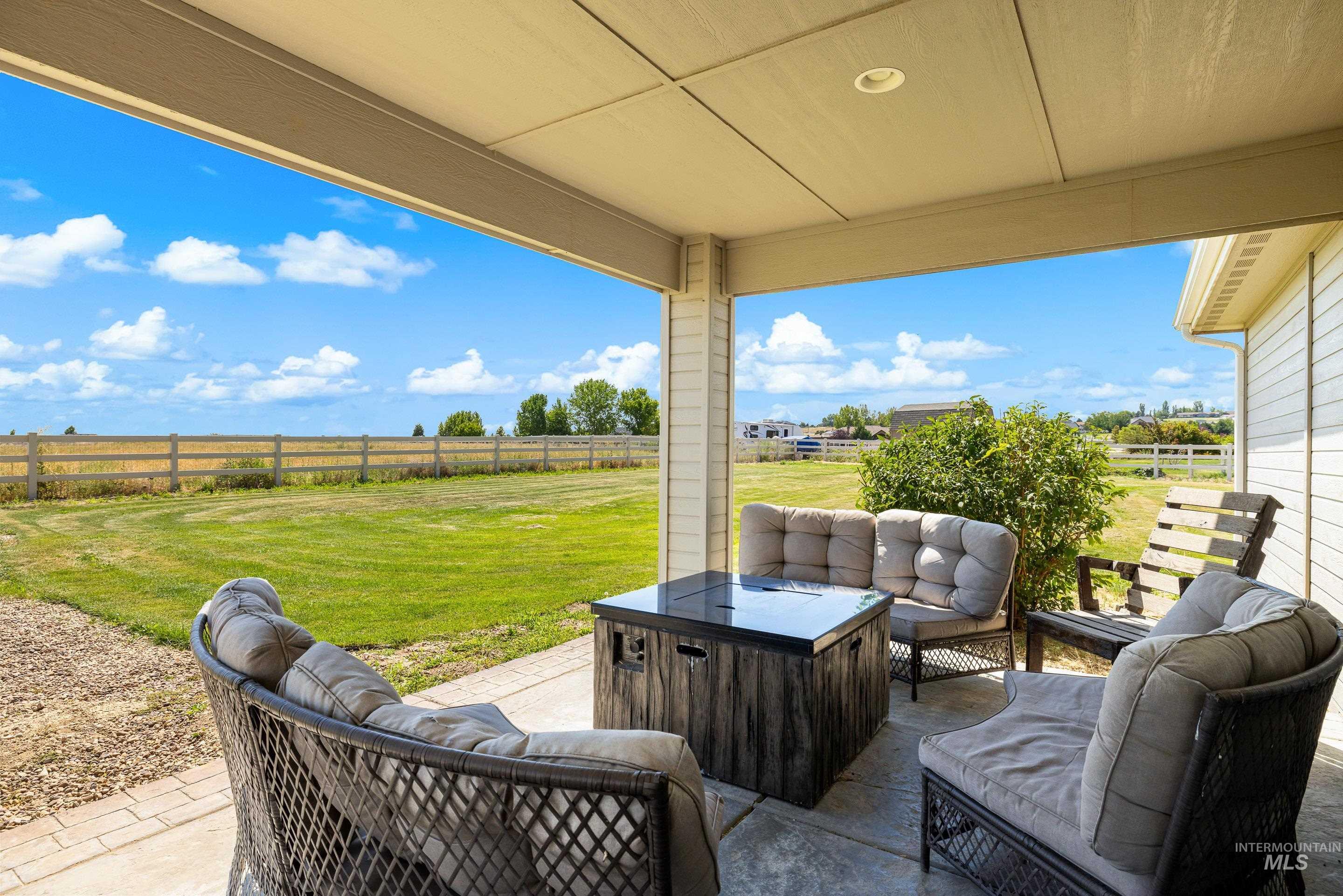 Fenced backyard featuring a patio, outdoor lounge area, and a rural view