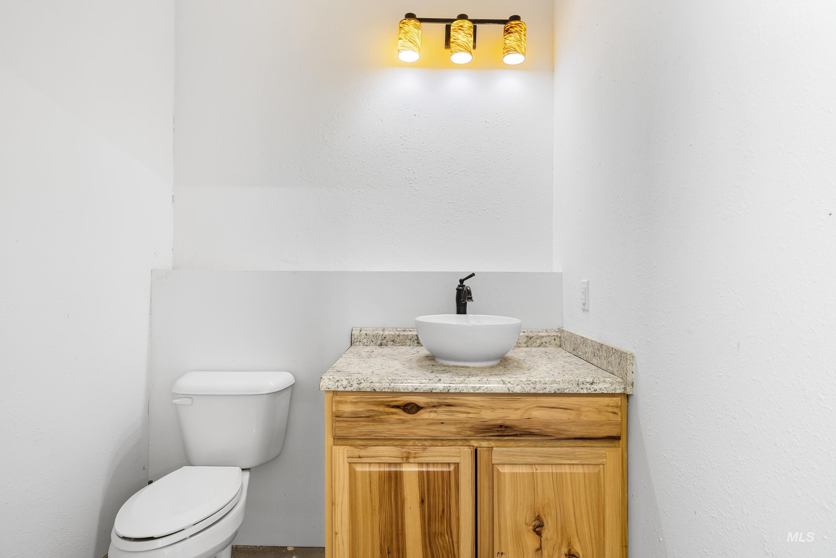 Half bathroom with vanity and a textured wall