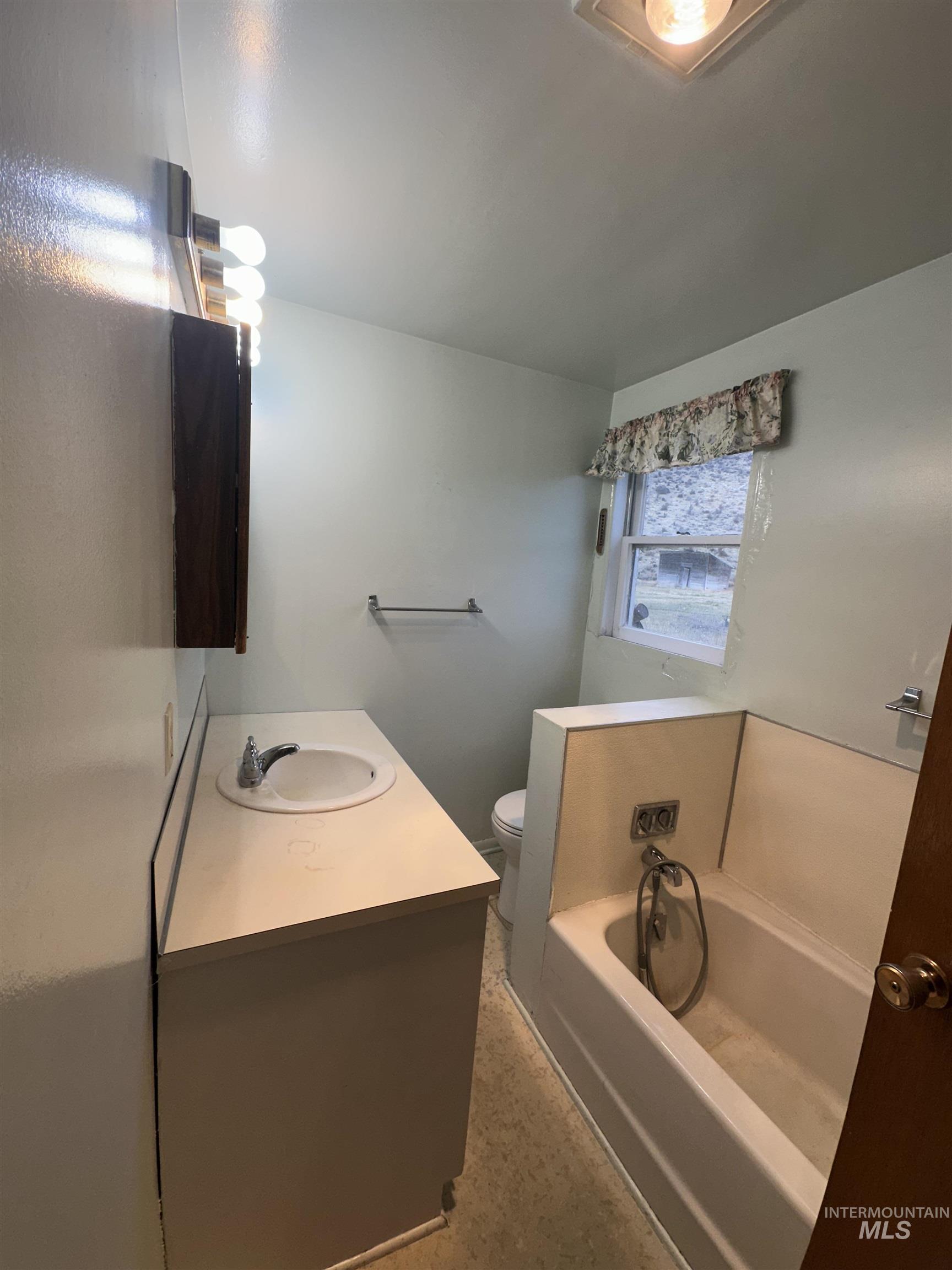 Full bathroom featuring a garden tub and vanity