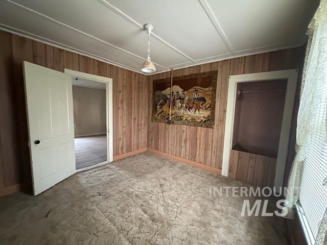 Unfurnished dining area with wooden walls and baseboards