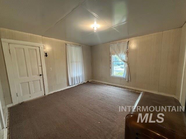 Spare room featuring carpet flooring and baseboards