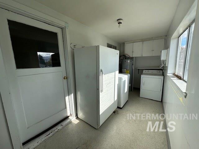 Washroom with light floors and washer and dryer