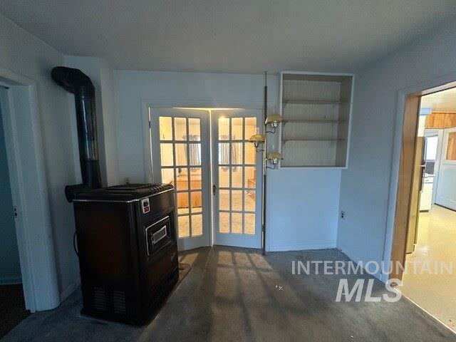 Doorway to outside with a wood stove and baseboards