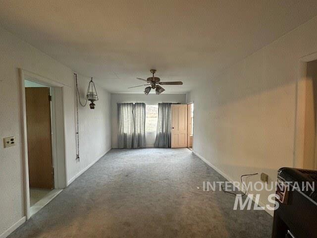 Unfurnished living room with carpet and ceiling fan