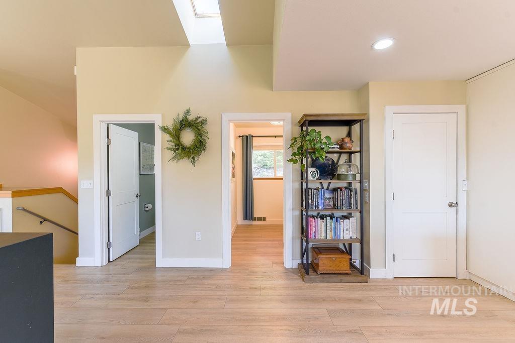 Bedroom with a skylight, light wood-style flooring, and recessed lighting