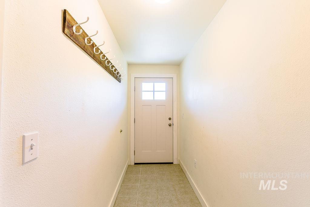 Doorway to outside featuring baseboards and tile patterned floors