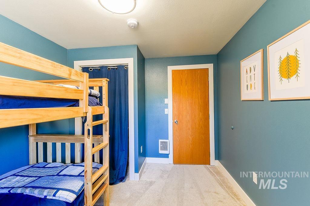 Carpeted bedroom featuring baseboards and a closet