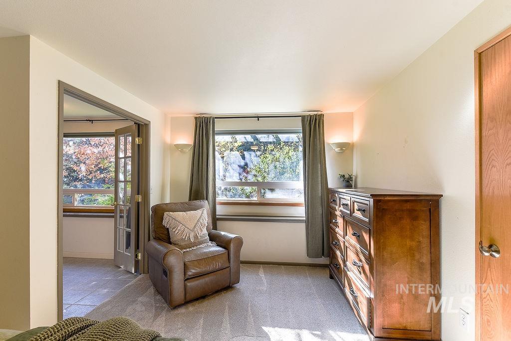 Living area featuring baseboards and light carpet