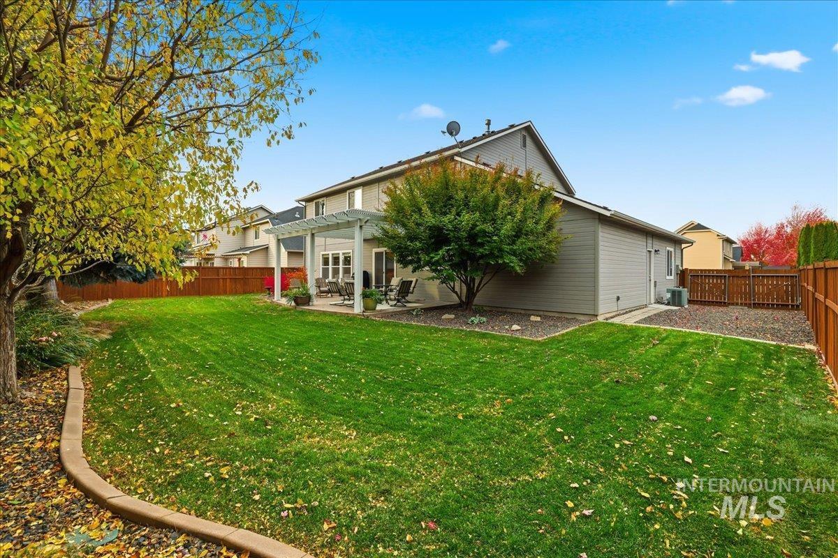 Rear view of house featuring a fenced backyard, a pergola, and a patio