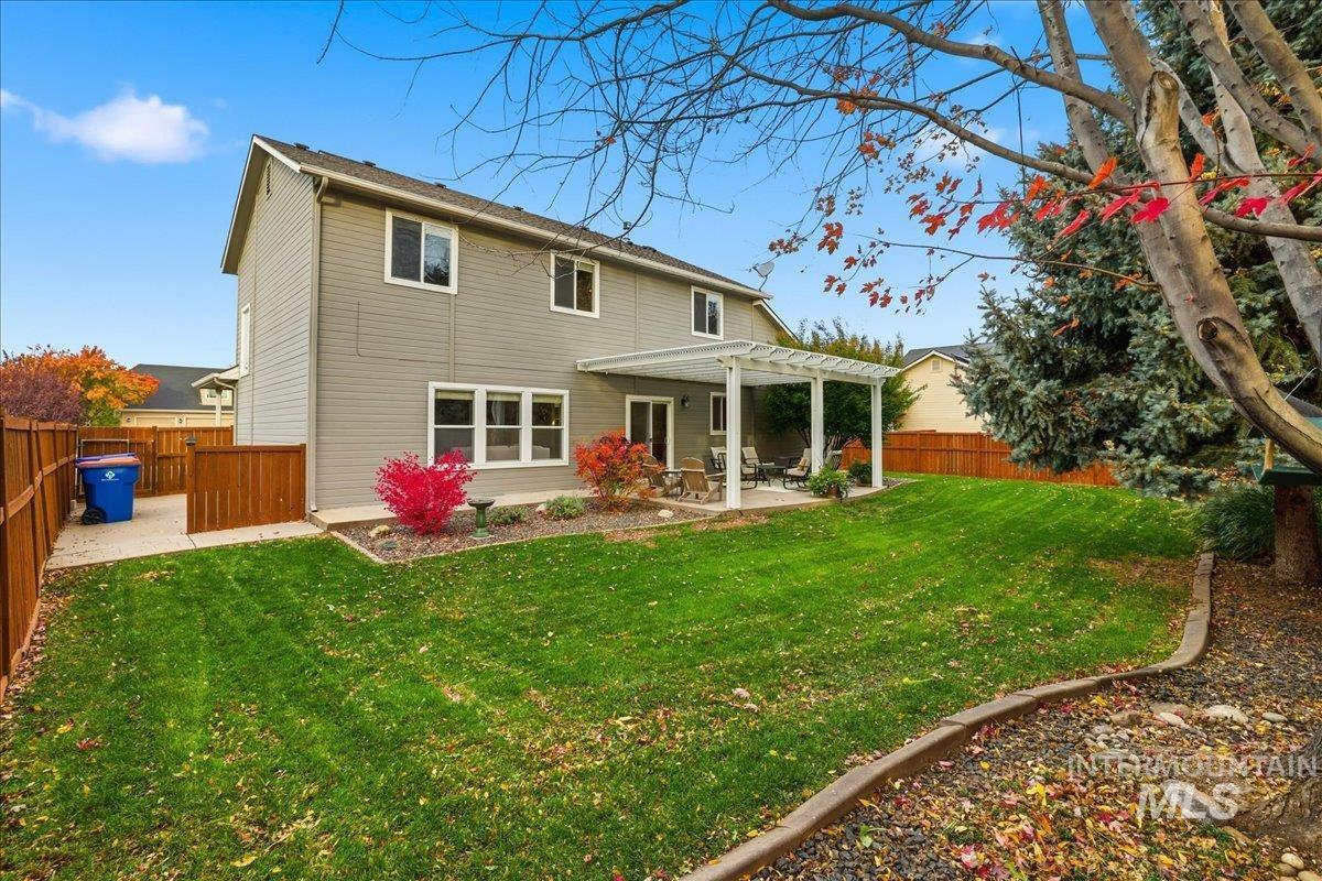 Rear view of house with a patio area, a fenced backyard, and a pergola