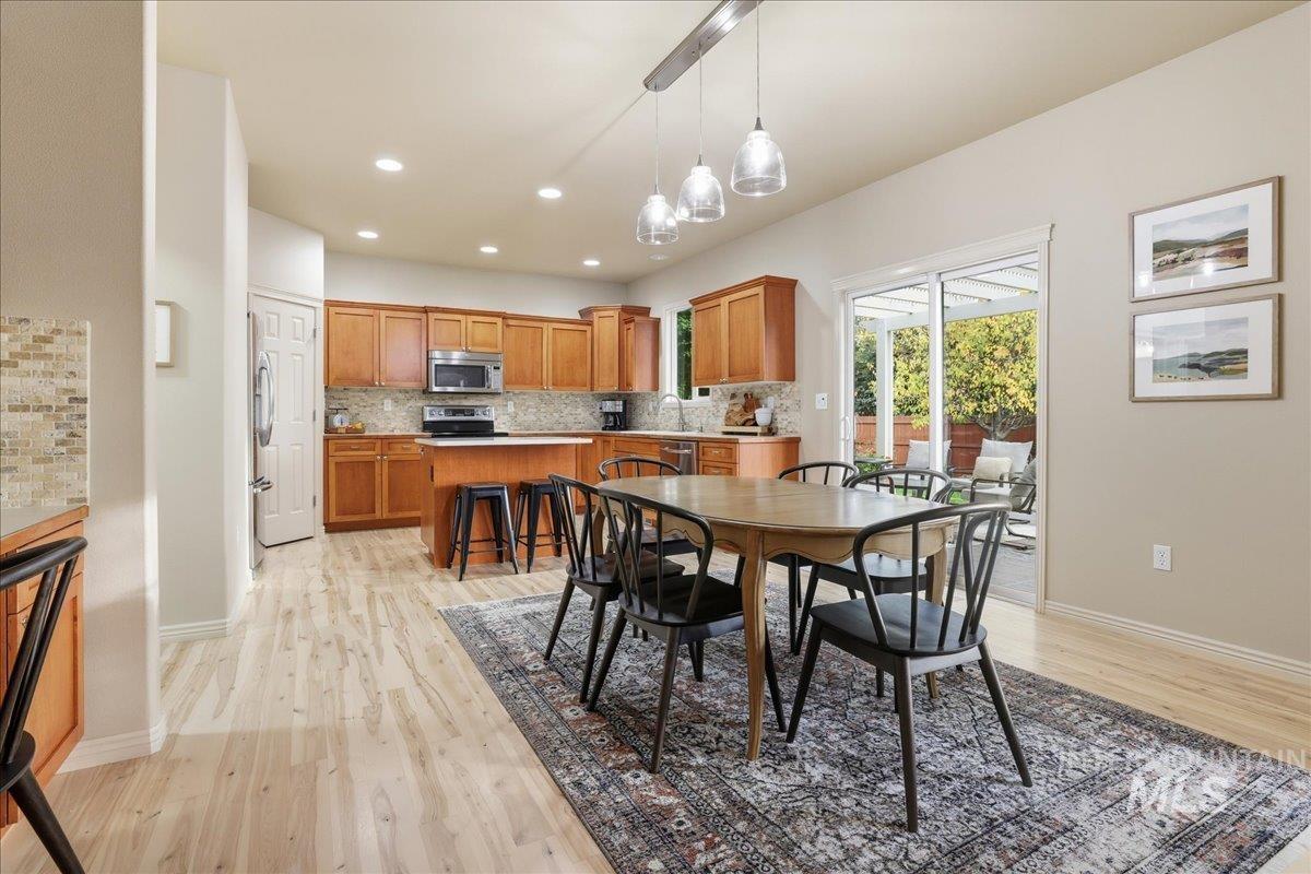 Dining area with light wood-type flooring and recessed lighting