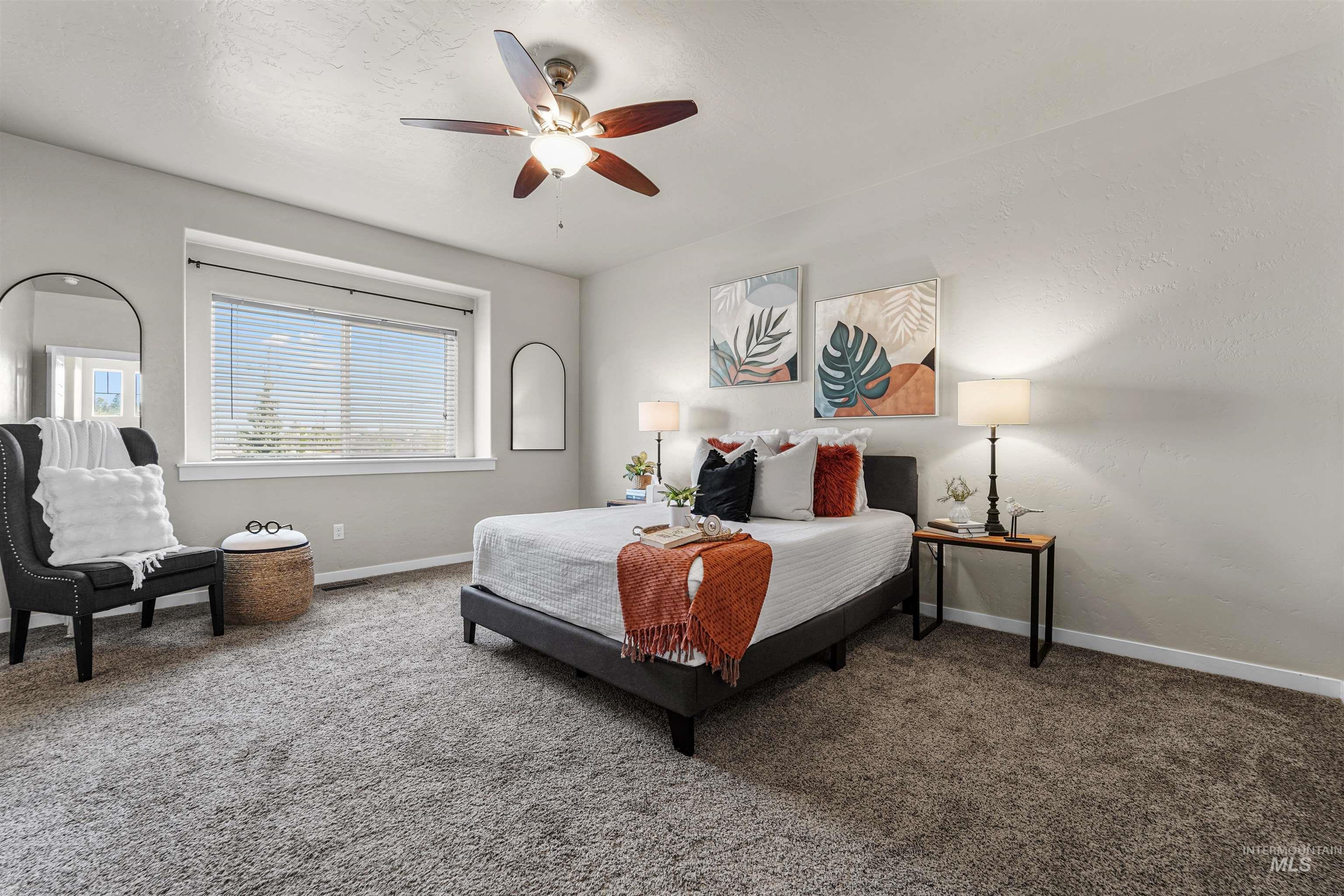 Carpeted bedroom featuring a ceiling fan and a textured ceiling