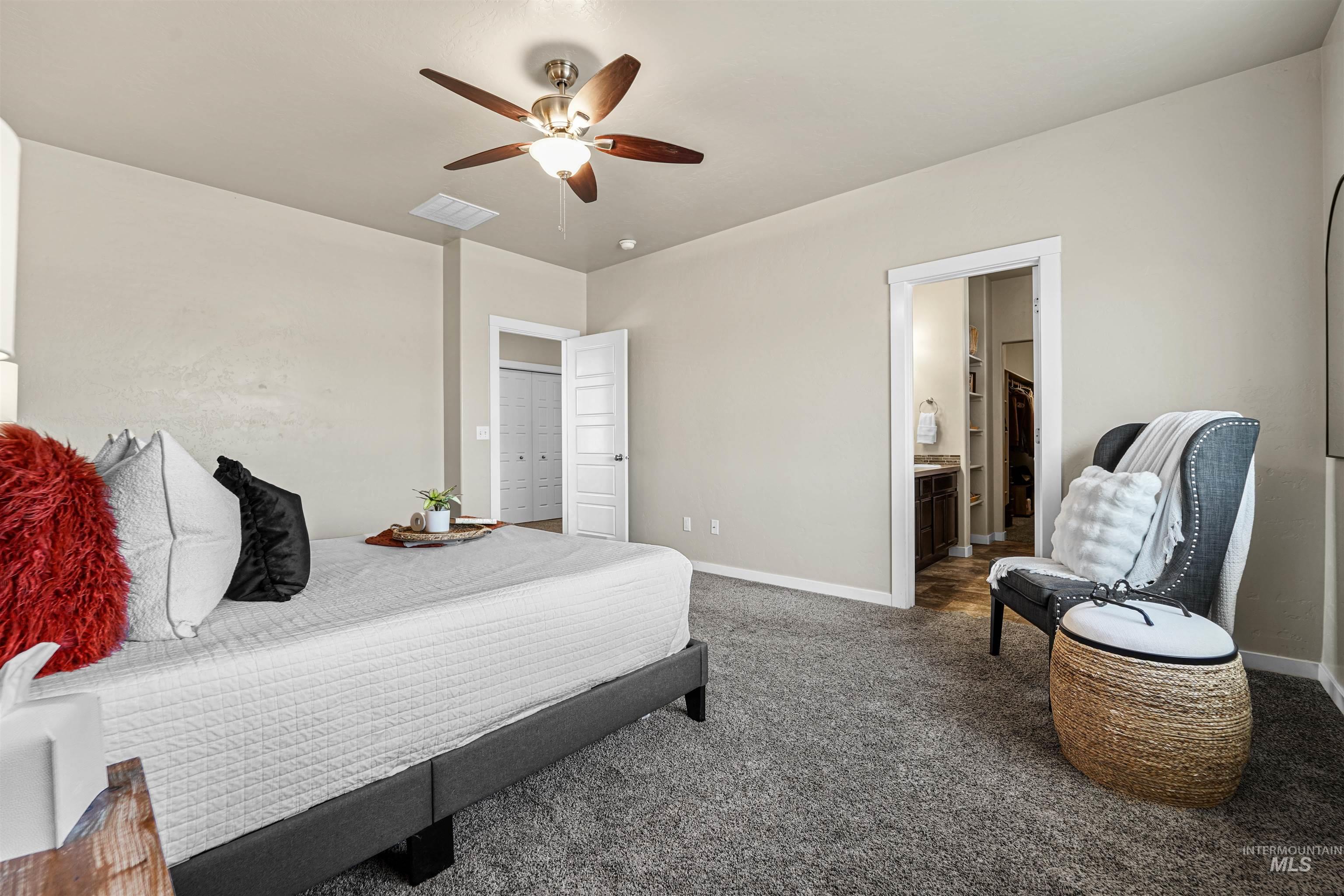 Carpeted bedroom featuring a ceiling fan and connected bathroom