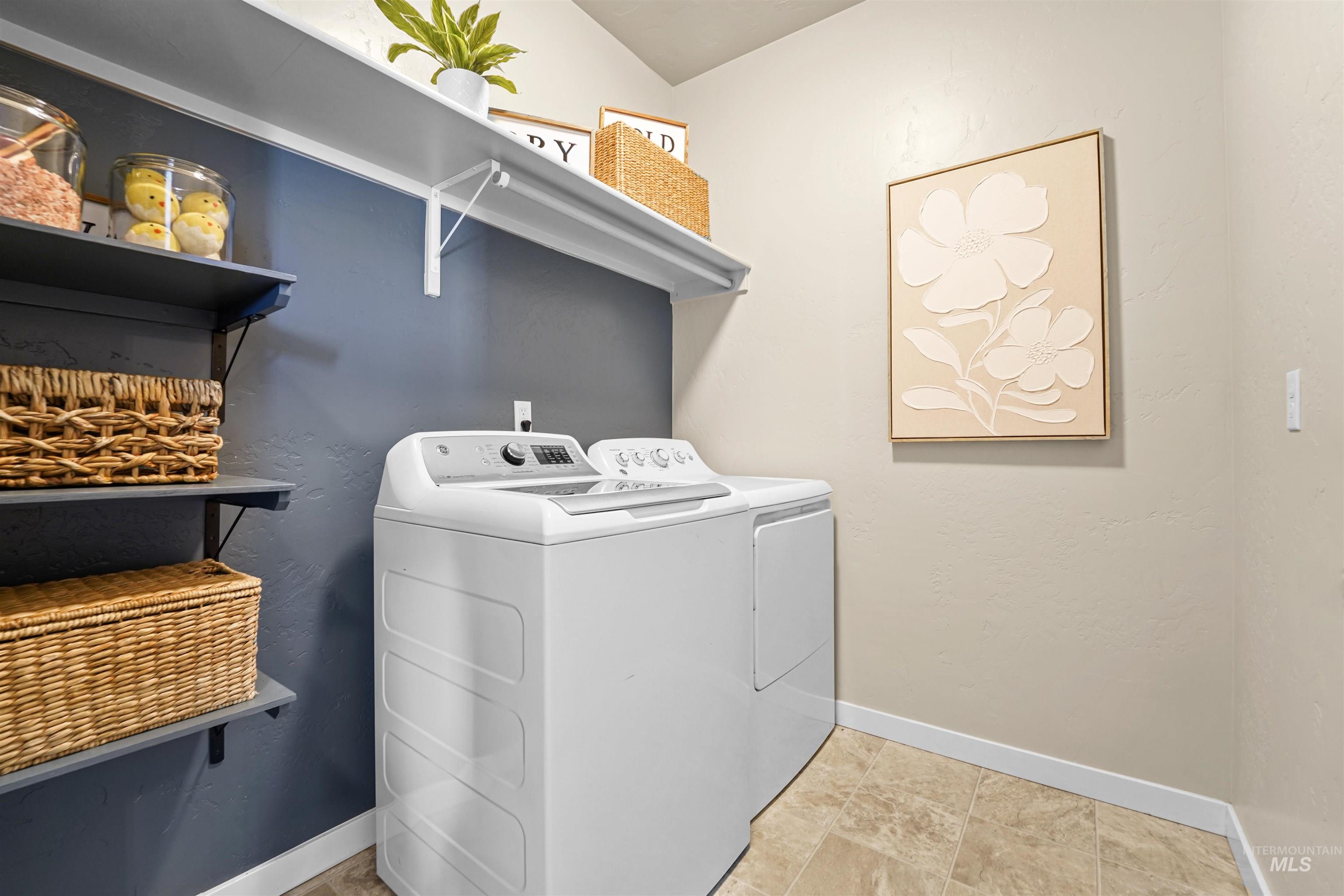 Washroom with washer and dryer and a textured wall