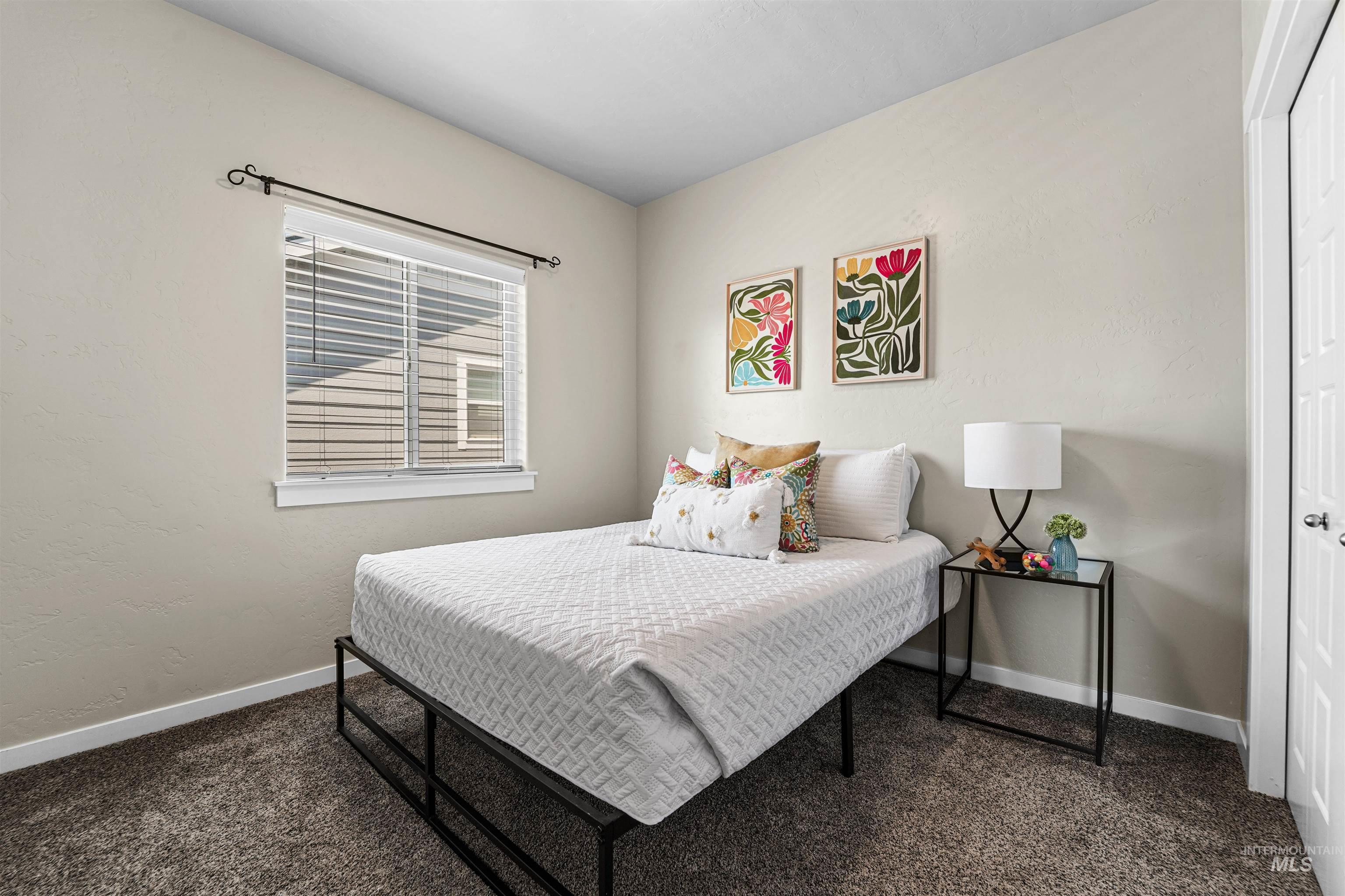Bedroom with dark colored carpet and a textured wall