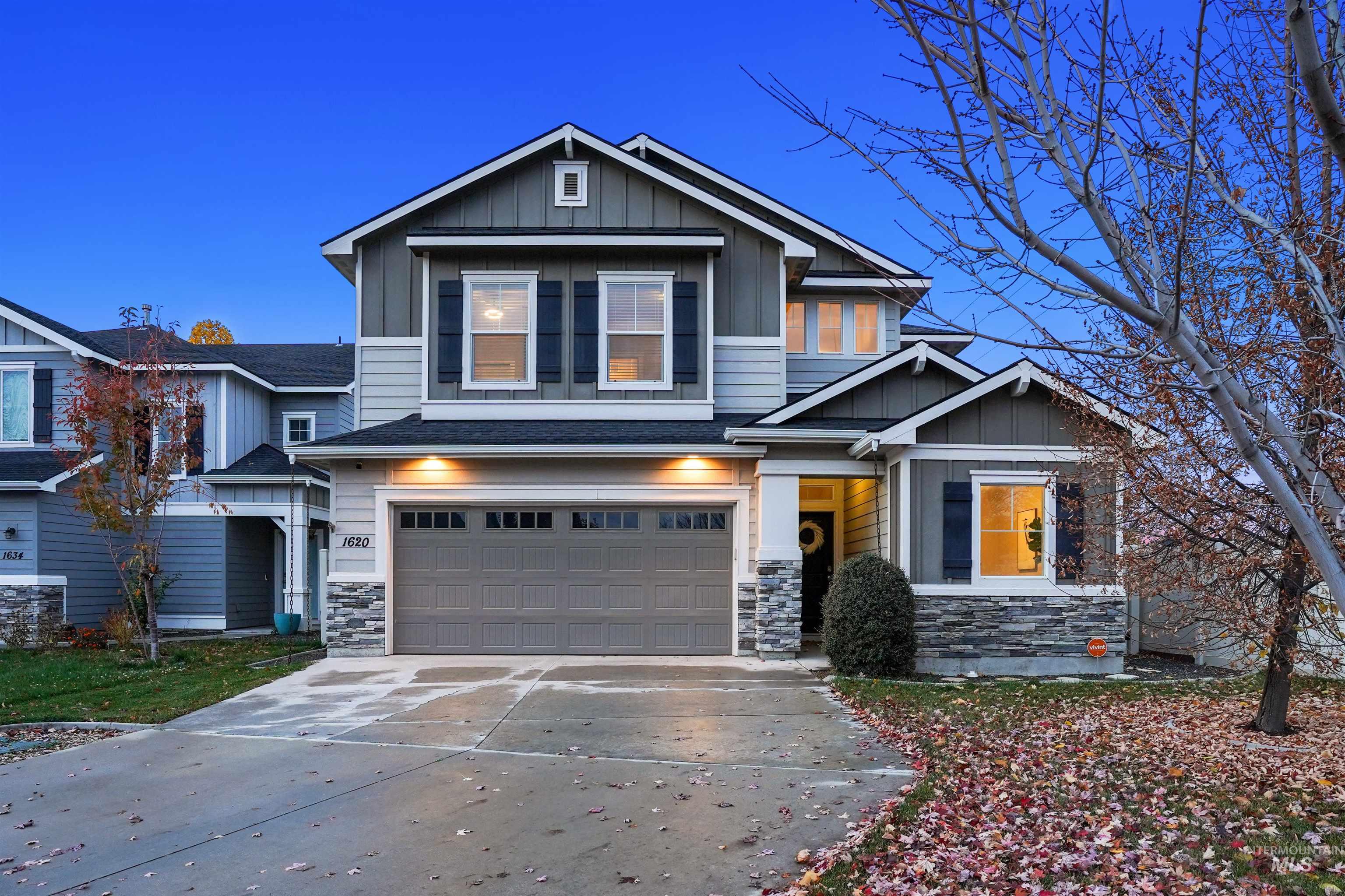 Craftsman house with board and batten siding, stone siding, concrete driveway, and a garage