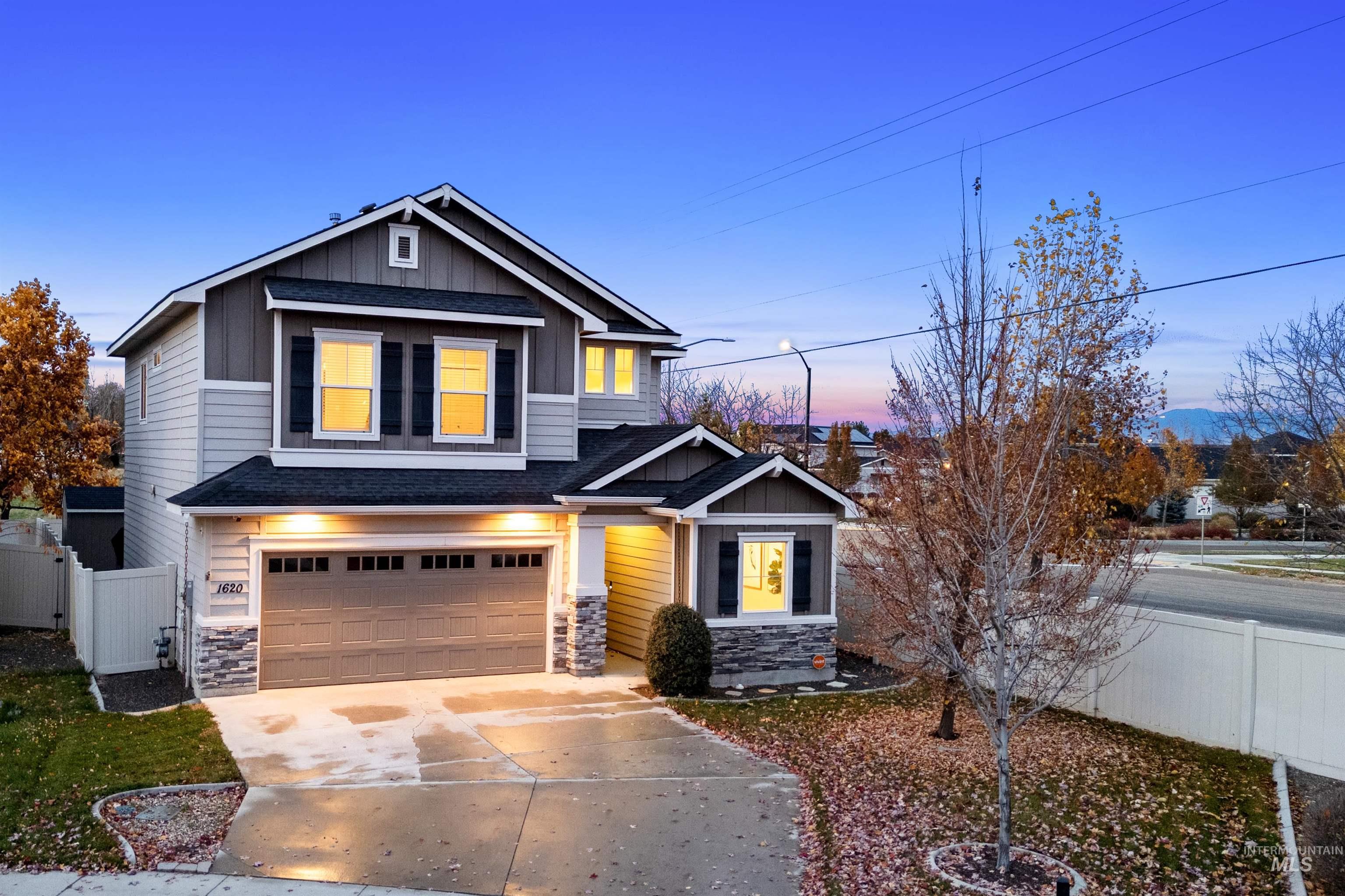 Craftsman-style house with stone siding, board and batten siding, a garage, concrete driveway, and a shingled roof