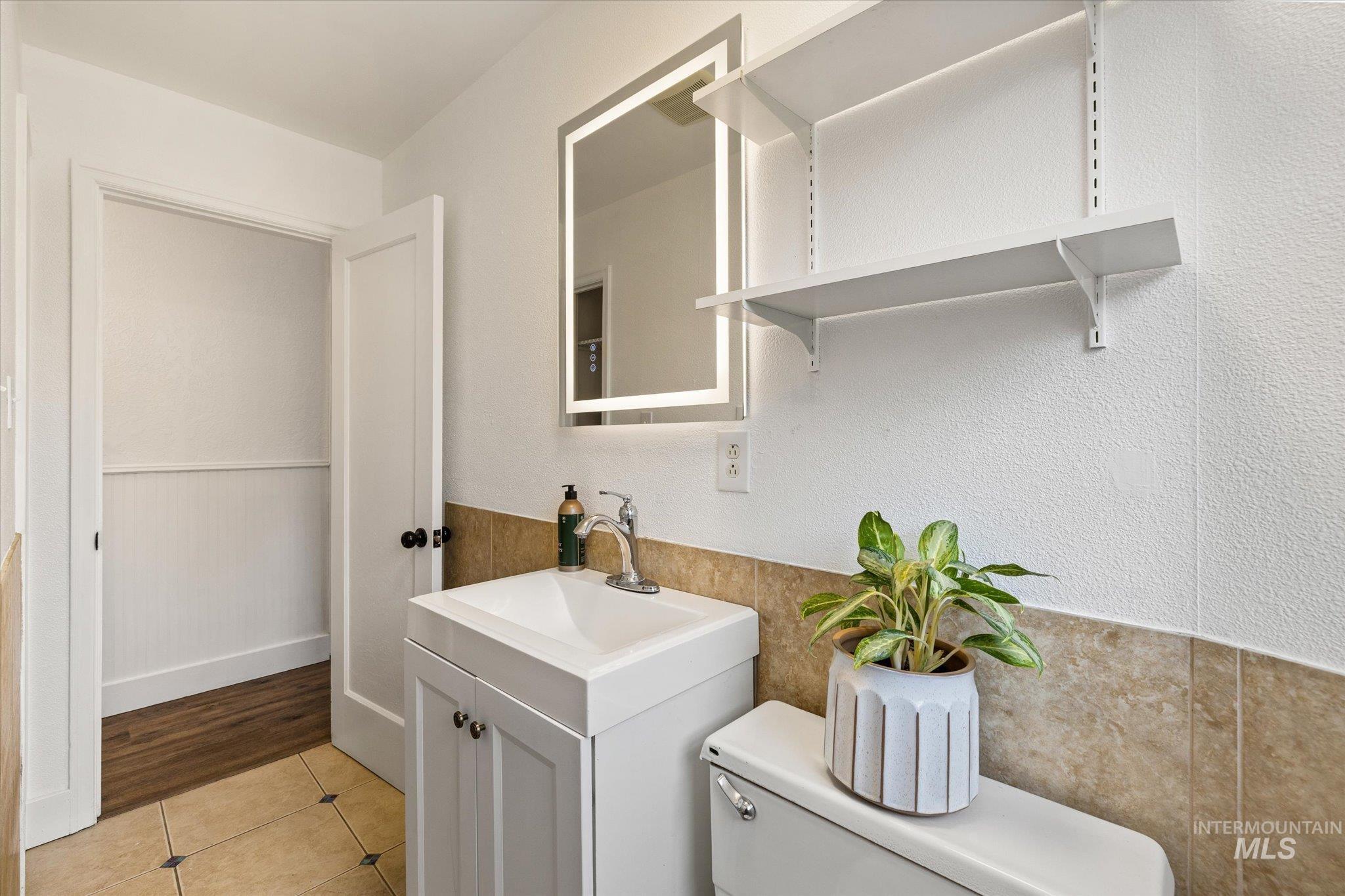 Laundry area with wainscoting and light tile patterned floors
