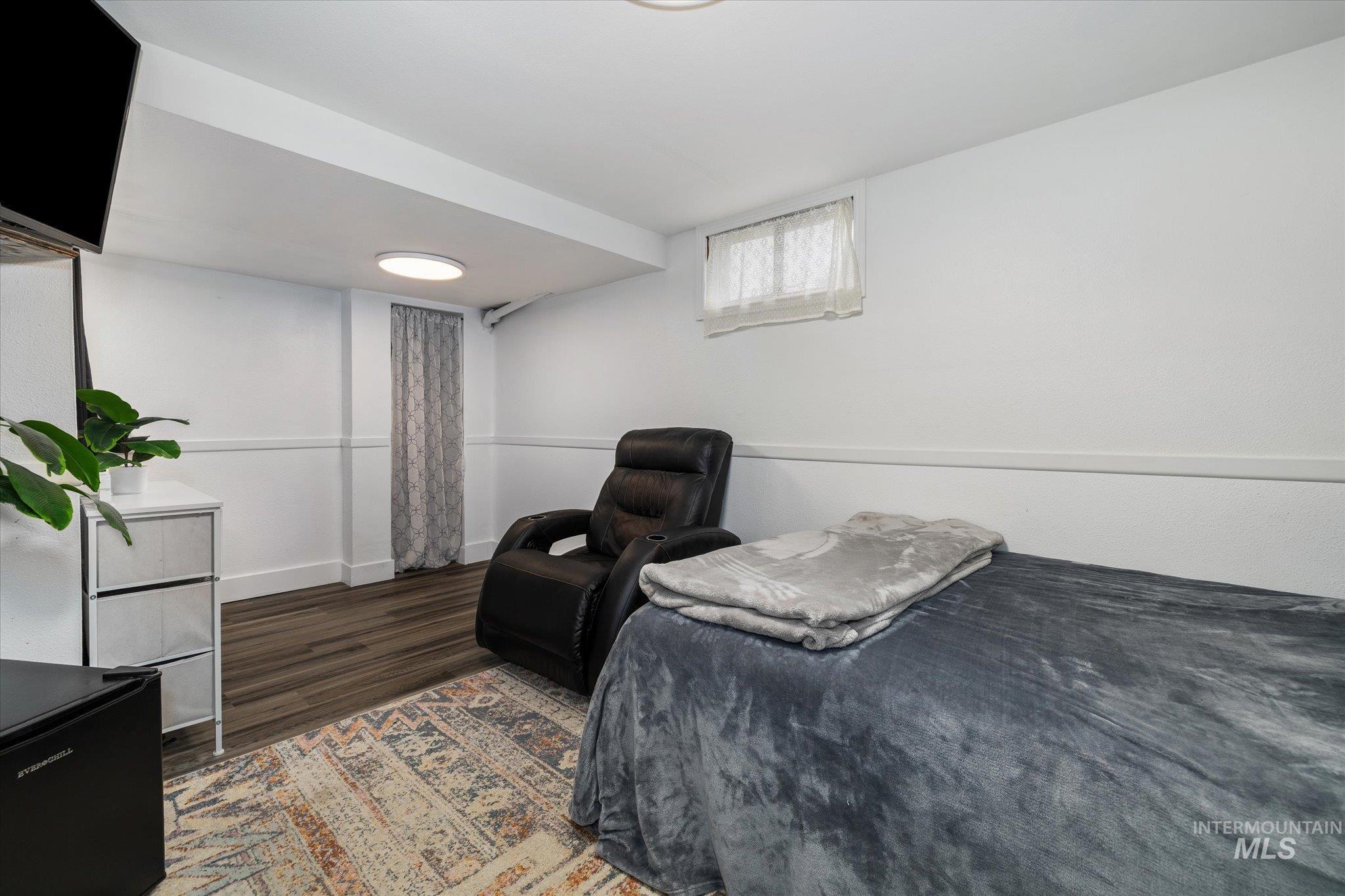 Bedroom featuring wood finished floors and baseboards